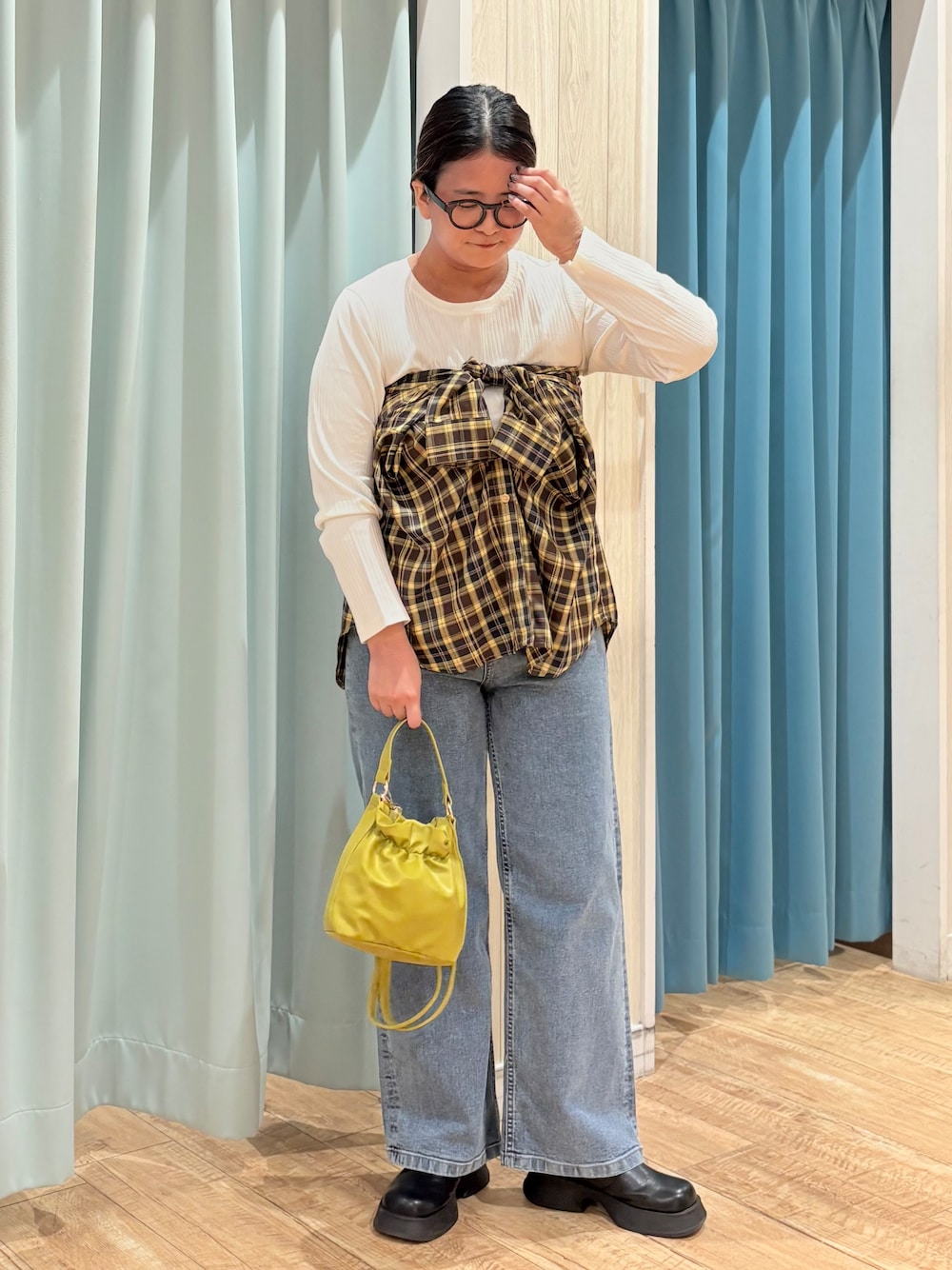 イエロー系のシャツ/ブラウス、ホワイト系のTシャツ/カットソー、ブルー系のデニムパンツを着用したレディースの秋コーディネートの1枚目の写真