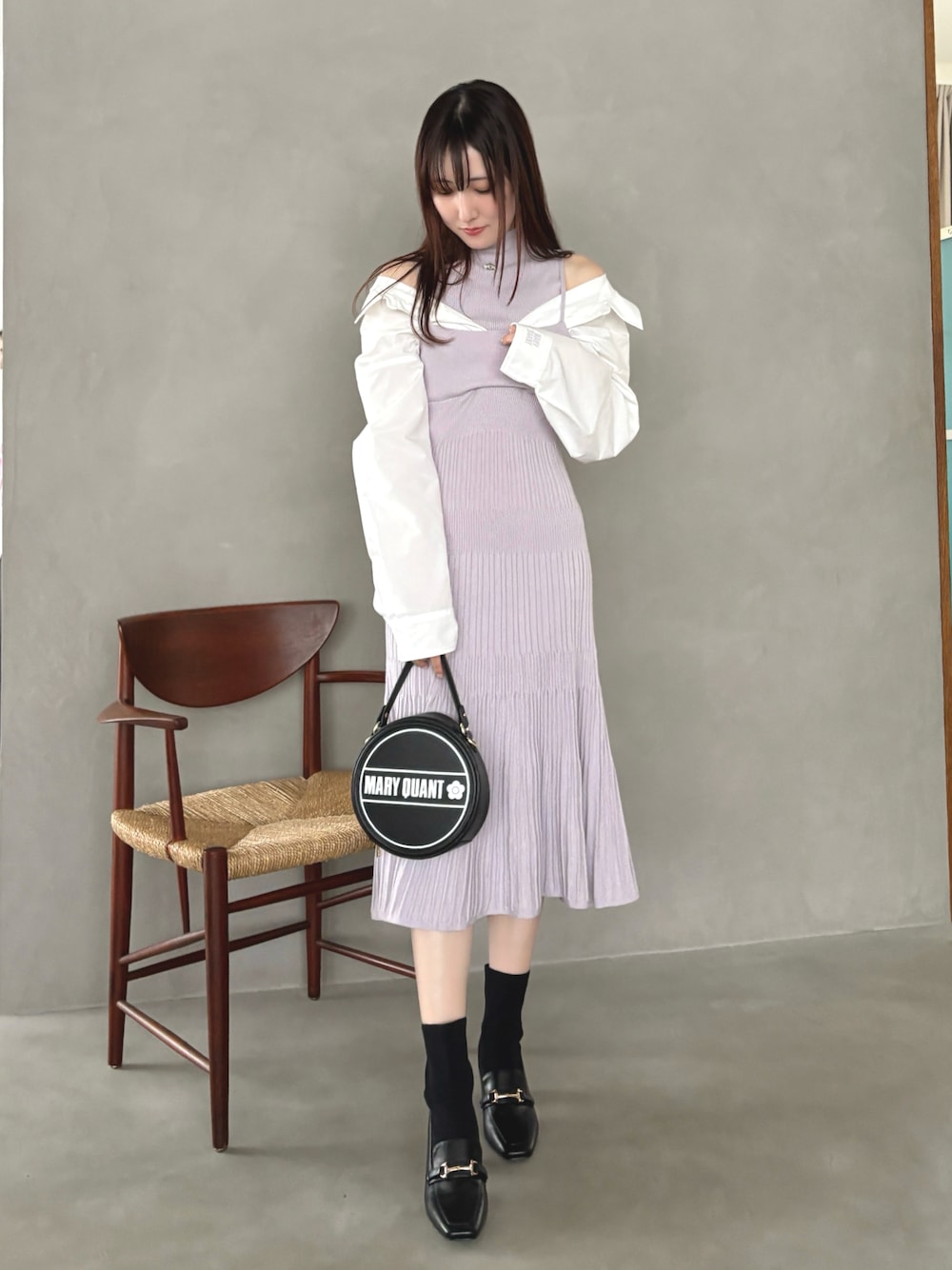 パープル系のワンピース、ブラック系のショルダーバッグ、グレー系のブーツを着用したレディースの冬コーディネートの1枚目の写真