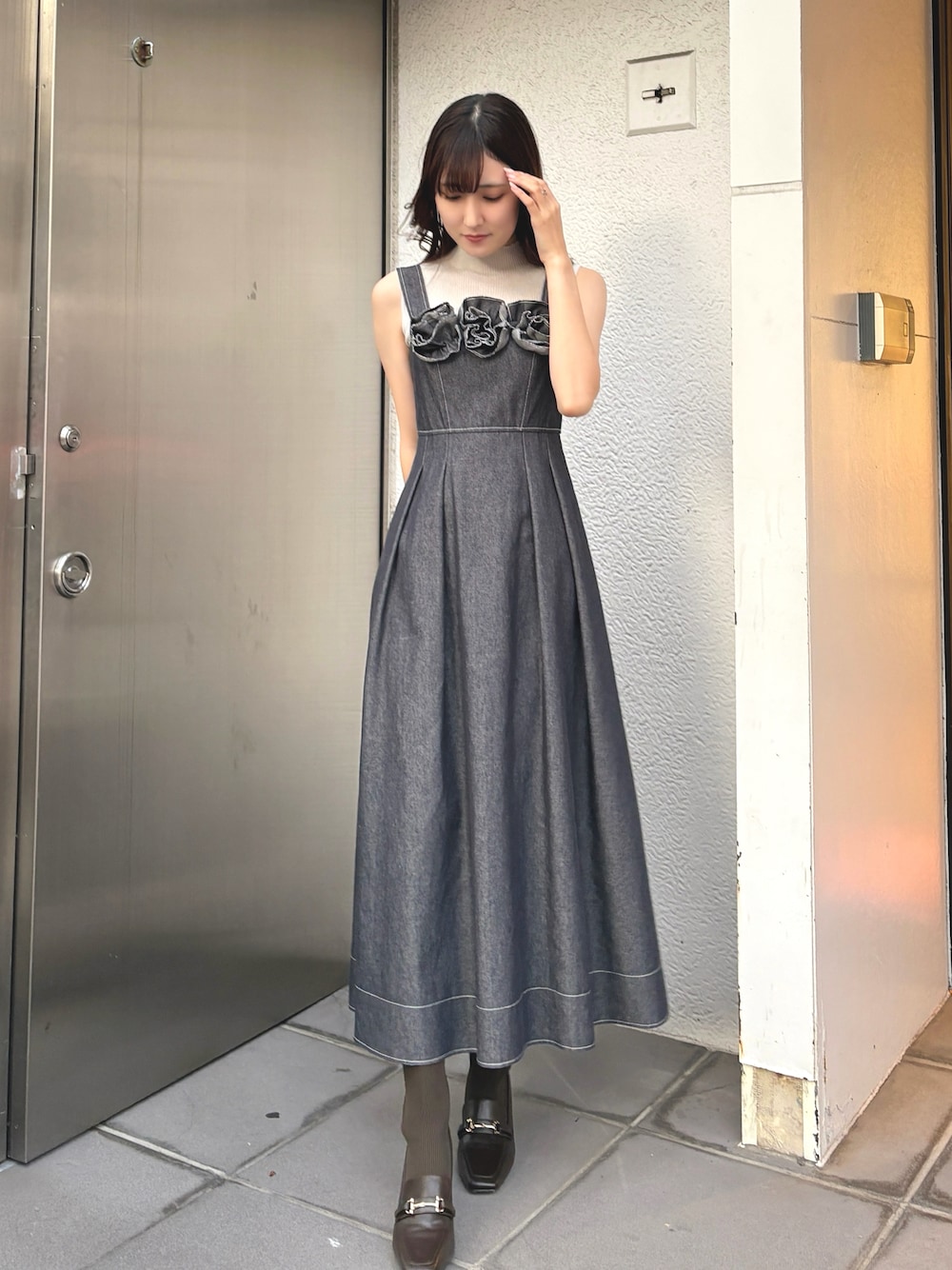 ブルー系のワンピース、ブラウン系のブーツを着用したレディースの秋コーディネートの1枚目の写真