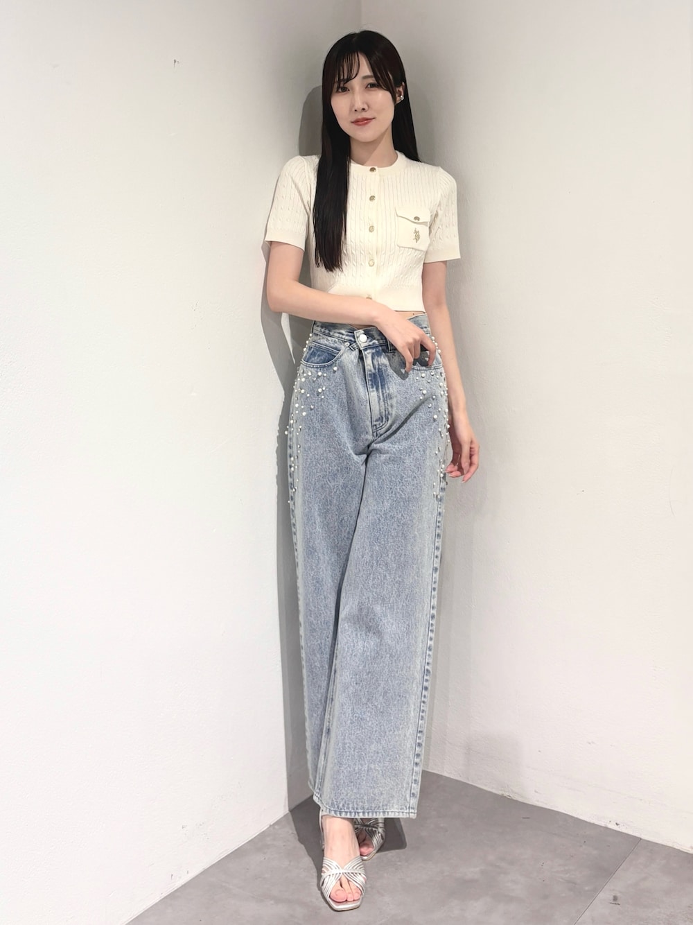 ブルー系のデニムパンツ、シルバー系のサンダル、ホワイト系のカーディガン/ボレロを着用したレディースの夏コーディネートの1枚目の写真