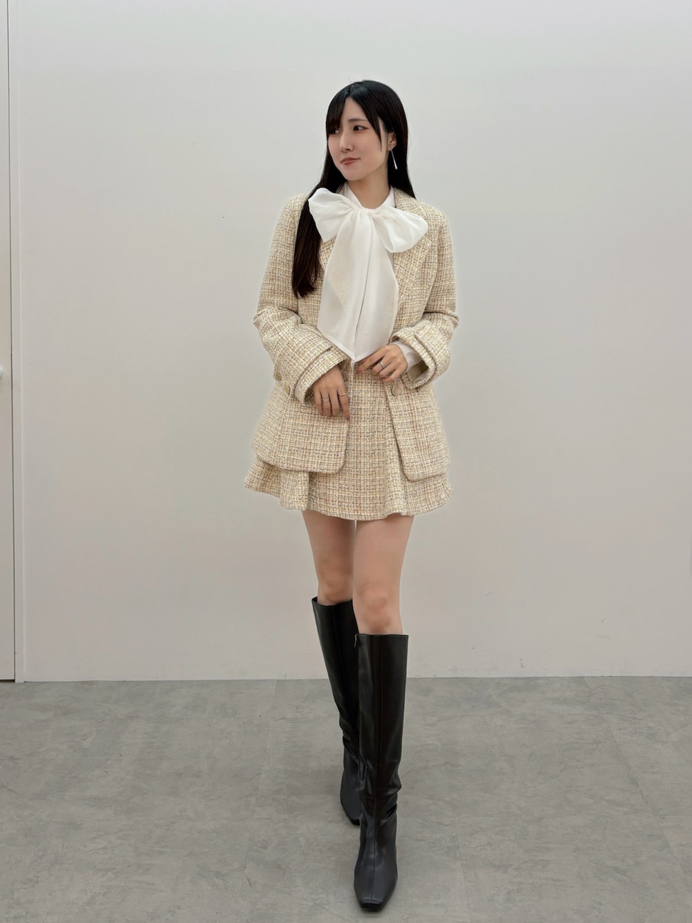 ブラウン系のブーツ、ホワイト系のシャツ/ブラウス、ベージュ系のテーラードジャケットを着用したレディースの冬コーディネートの1枚目の写真