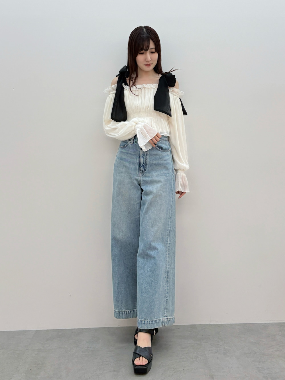 ホワイト系のシャツ/ブラウス、ブルー系のデニムパンツ、ブラック系のサンダルを着用したレディースの春コーディネートの1枚目の写真