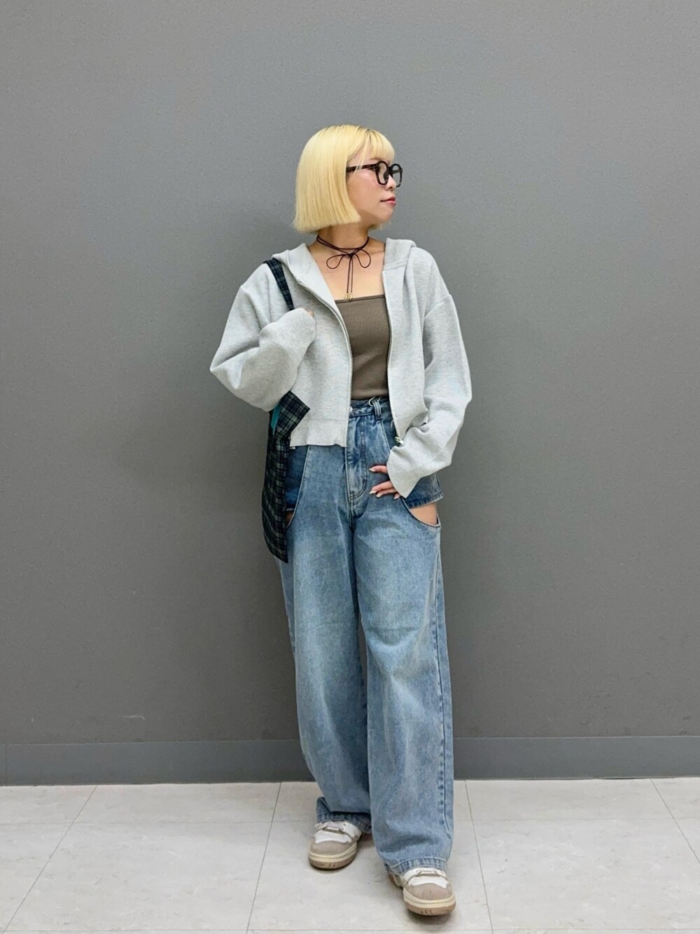 ブルー系のデニムパンツ、グレー系のニット/セーター、ブルー系のトートバッグを着用したレディースの秋コーディネートの1枚目の写真