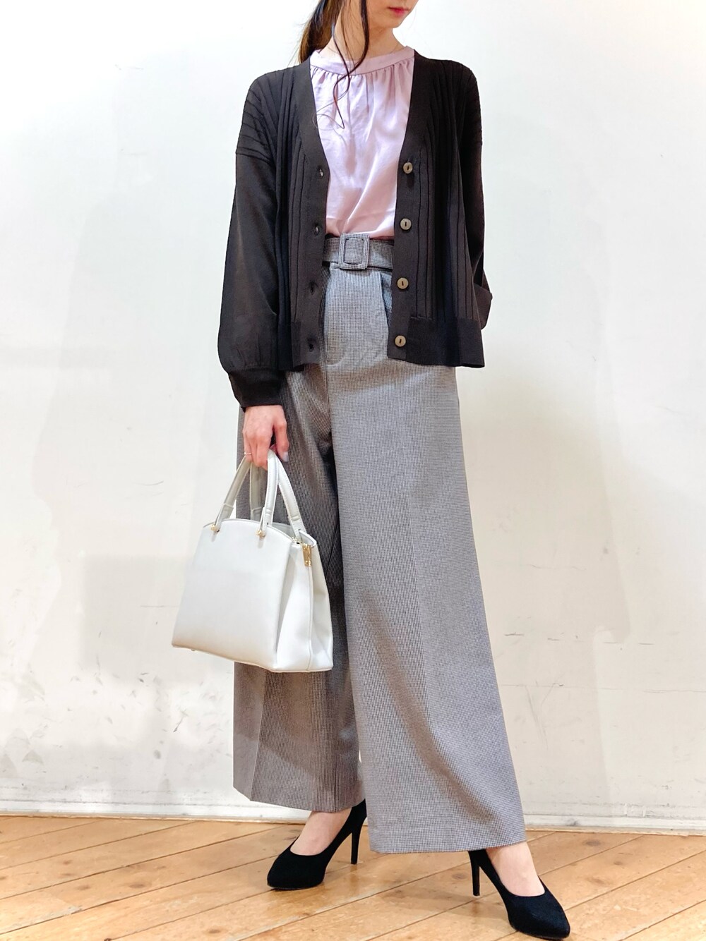 ブラック系のショルダーバッグ、ブラウン系のカーディガン/ボレロ、ピンク系のシャツ/ブラウスを着用したレディースの冬コーディネートの1枚目の写真