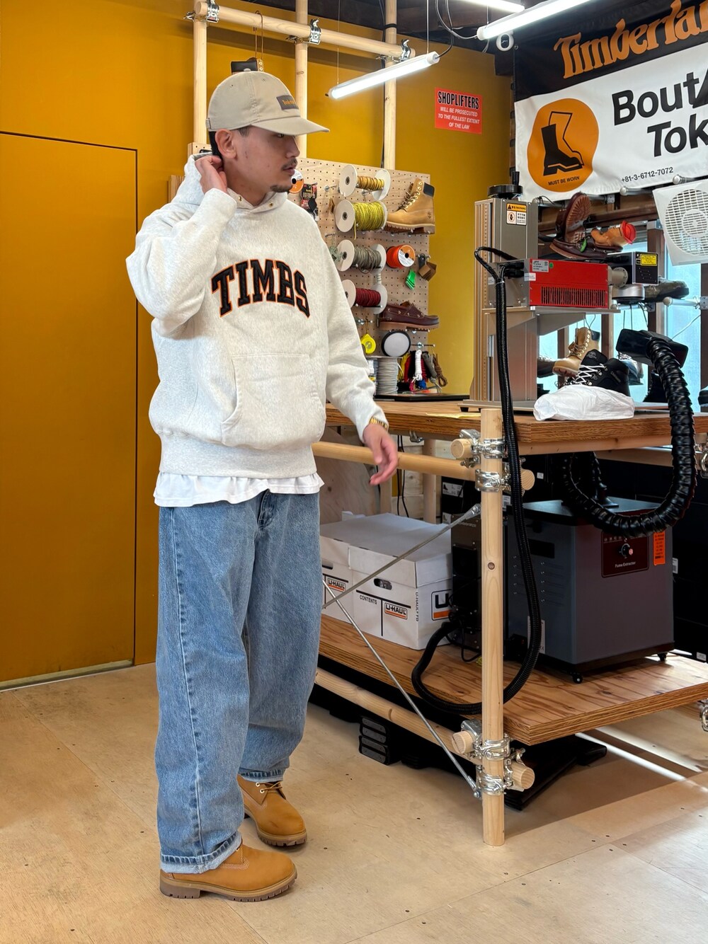 ホワイト系のパーカー、イエロー系のブーツを着用したメンズの春コーディネートの1枚目の写真