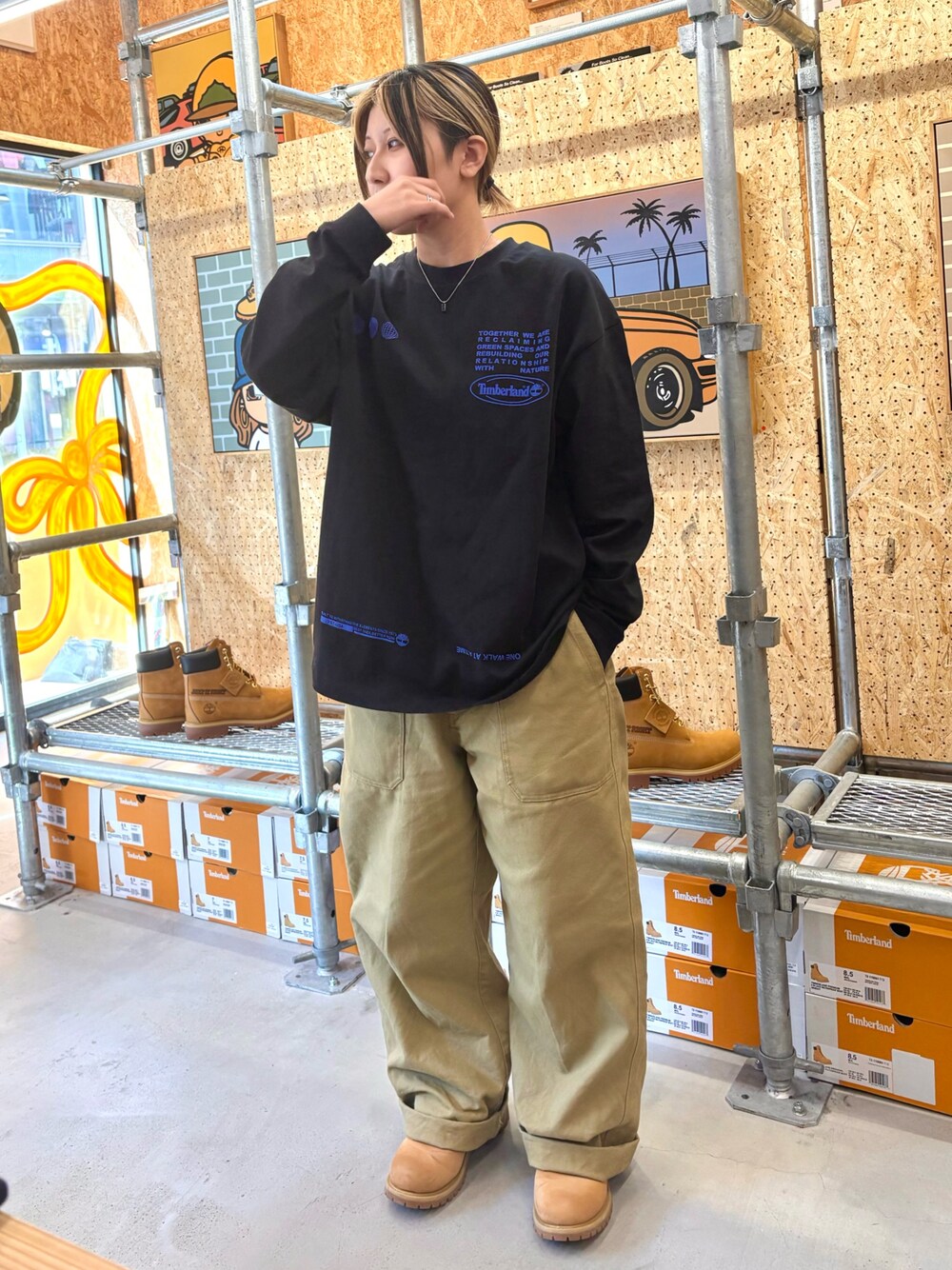 ブラック系のTシャツ/カットソー、グリーン系のその他パンツ、イエロー系のブーツを着用したレディースの秋コーディネートの1枚目の写真