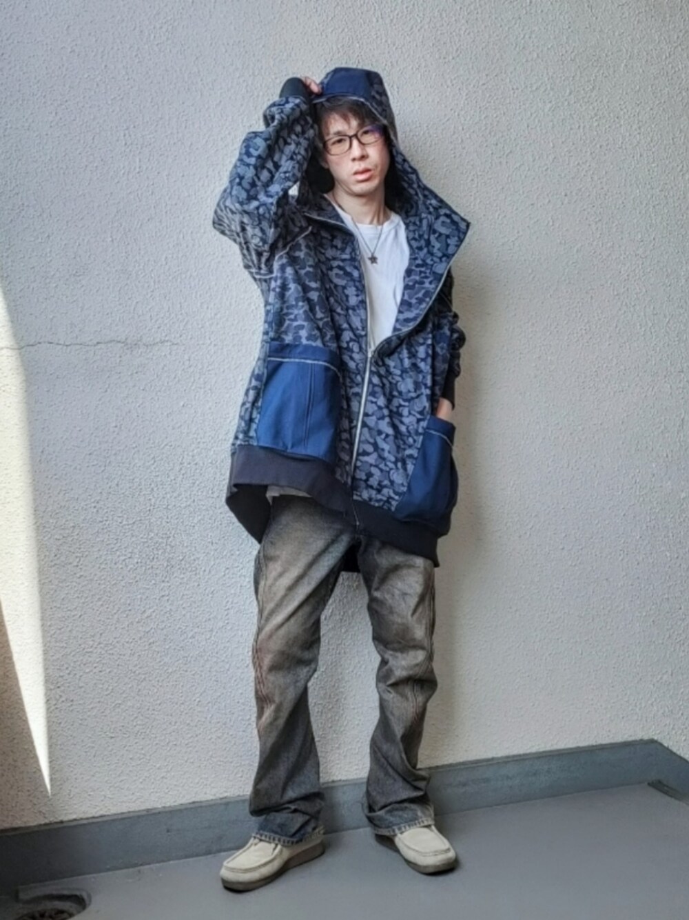 ブルー系のパーカー、ブラウン系のデニムパンツ、ベージュ系のシューズを着用したメンズの春コーディネートの1枚目の写真