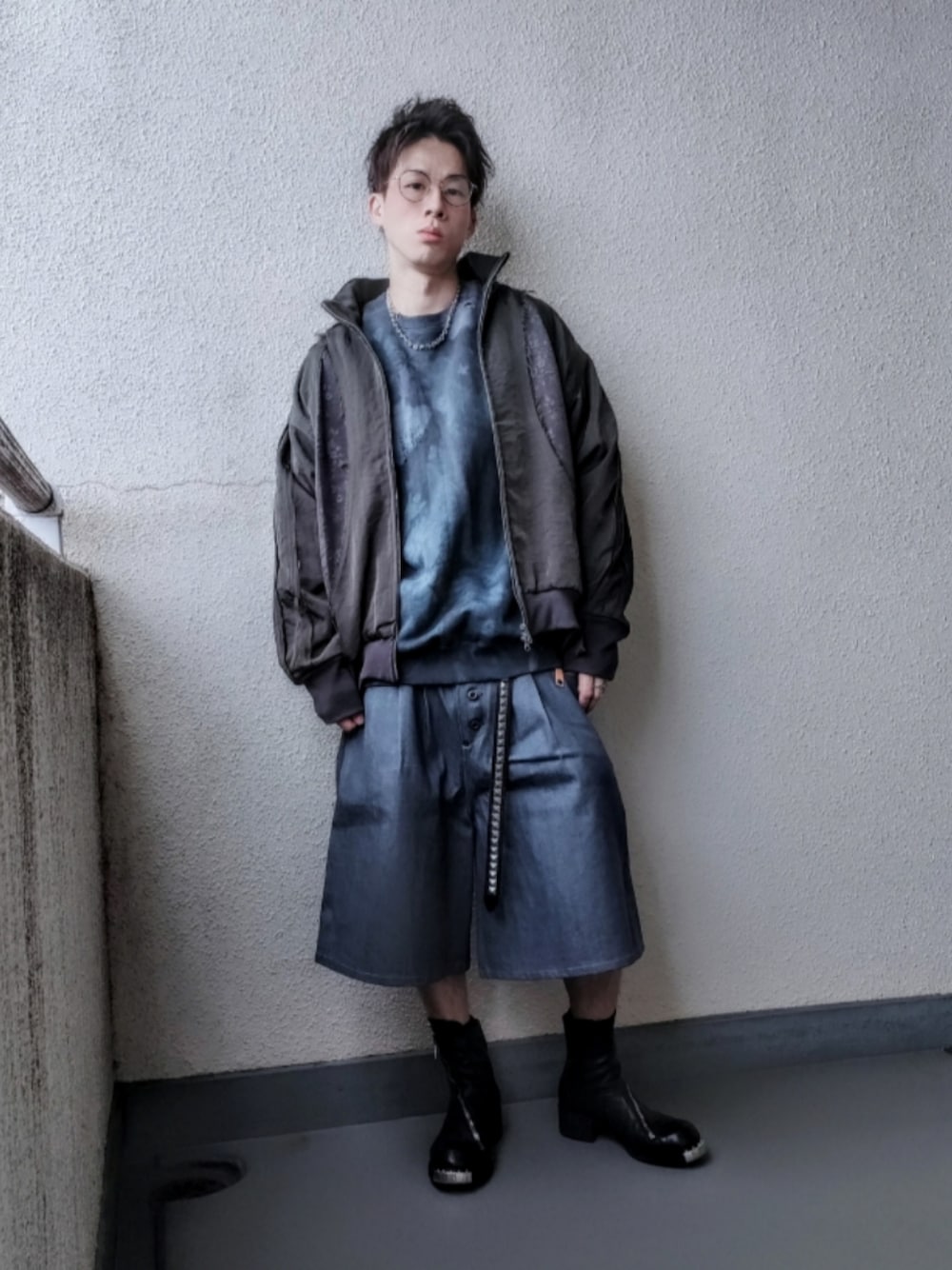 グリーン系のブルゾン、グリーン系のスウェット、ブラック系のブーツを着用したメンズの春コーディネートの1枚目の写真