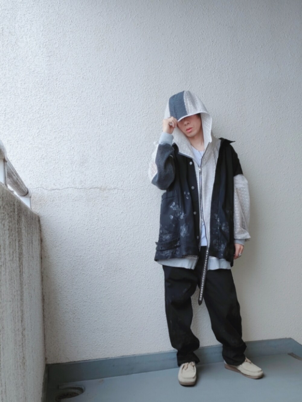 ブラック系のデニムパンツ、ブラック系のベスト、ベージュ系のシューズを着用したメンズの春コーディネートの1枚目の写真