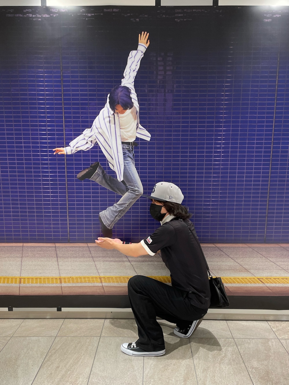 ブラック系のスニーカー、ブラック系のショルダーバッグ、ブラック系のTシャツ/カットソーを着用したメンズの秋コーディネートの1枚目の写真