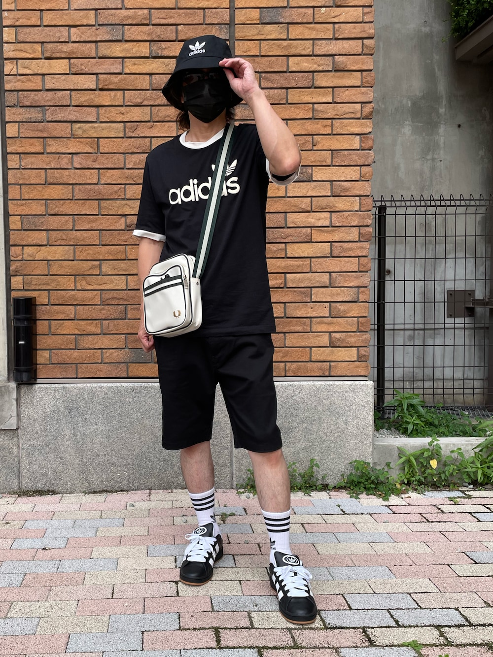 ブラック系のTシャツ/カットソー、ブラック系のその他パンツ、ホワイト系のショルダーバッグを着用したメンズの夏コーディネートの1枚目の写真