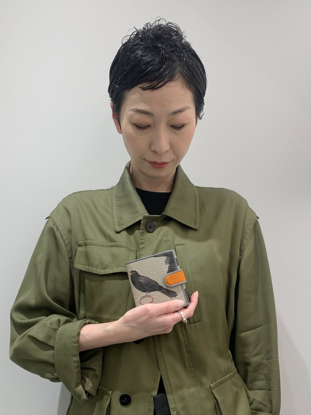 オレンジ系の財布を着用したレディースの春コーディネートの1枚目の写真