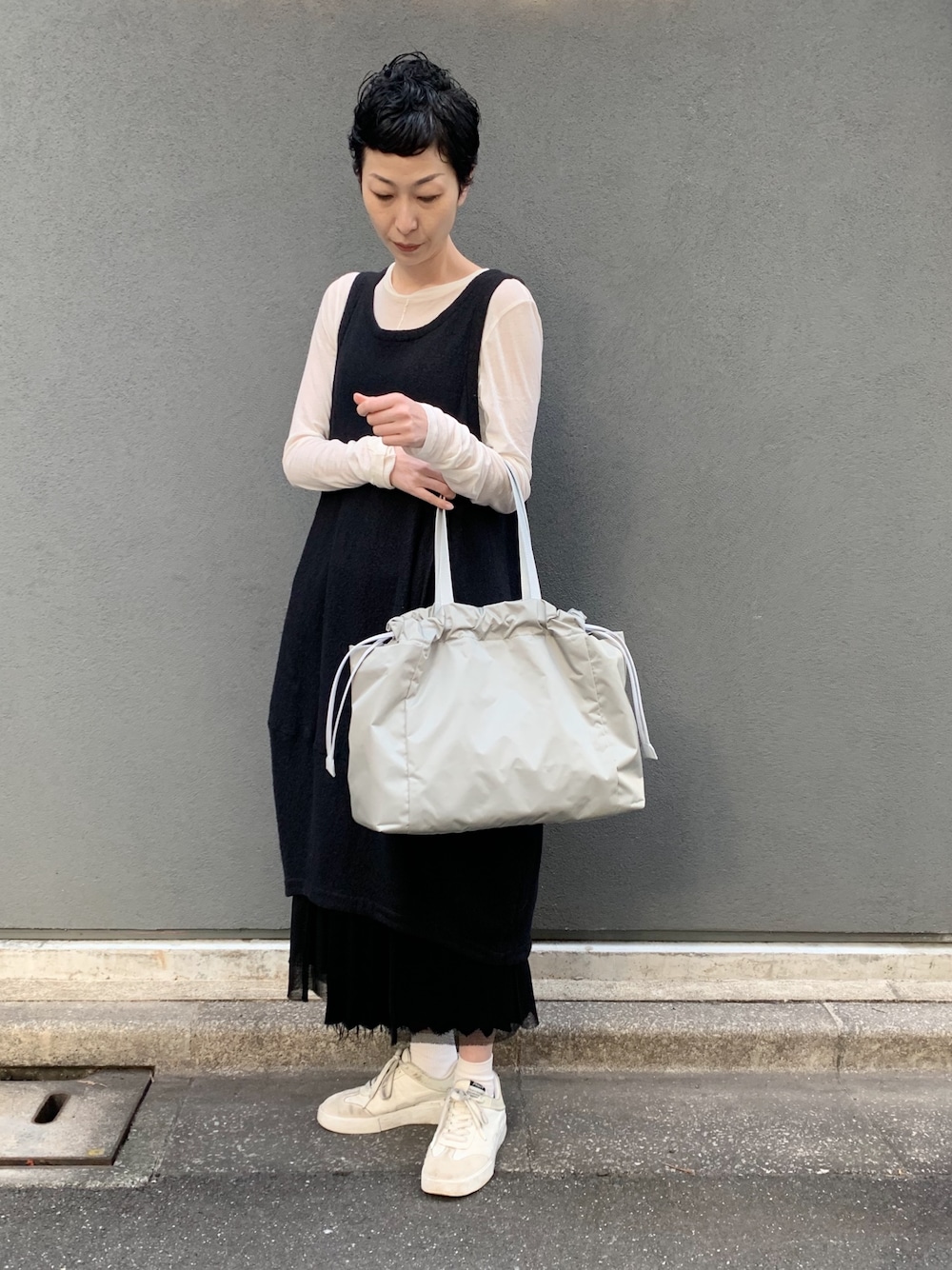 グリーン系のトートバッグを着用したレディースの春コーディネートの1枚目の写真