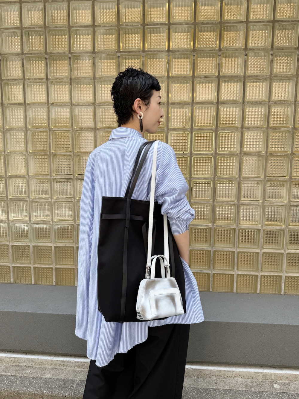 グレー系のショルダーバッグ、ブラック系のトートバッグを着用したレディースの春コーディネートの1枚目の写真
