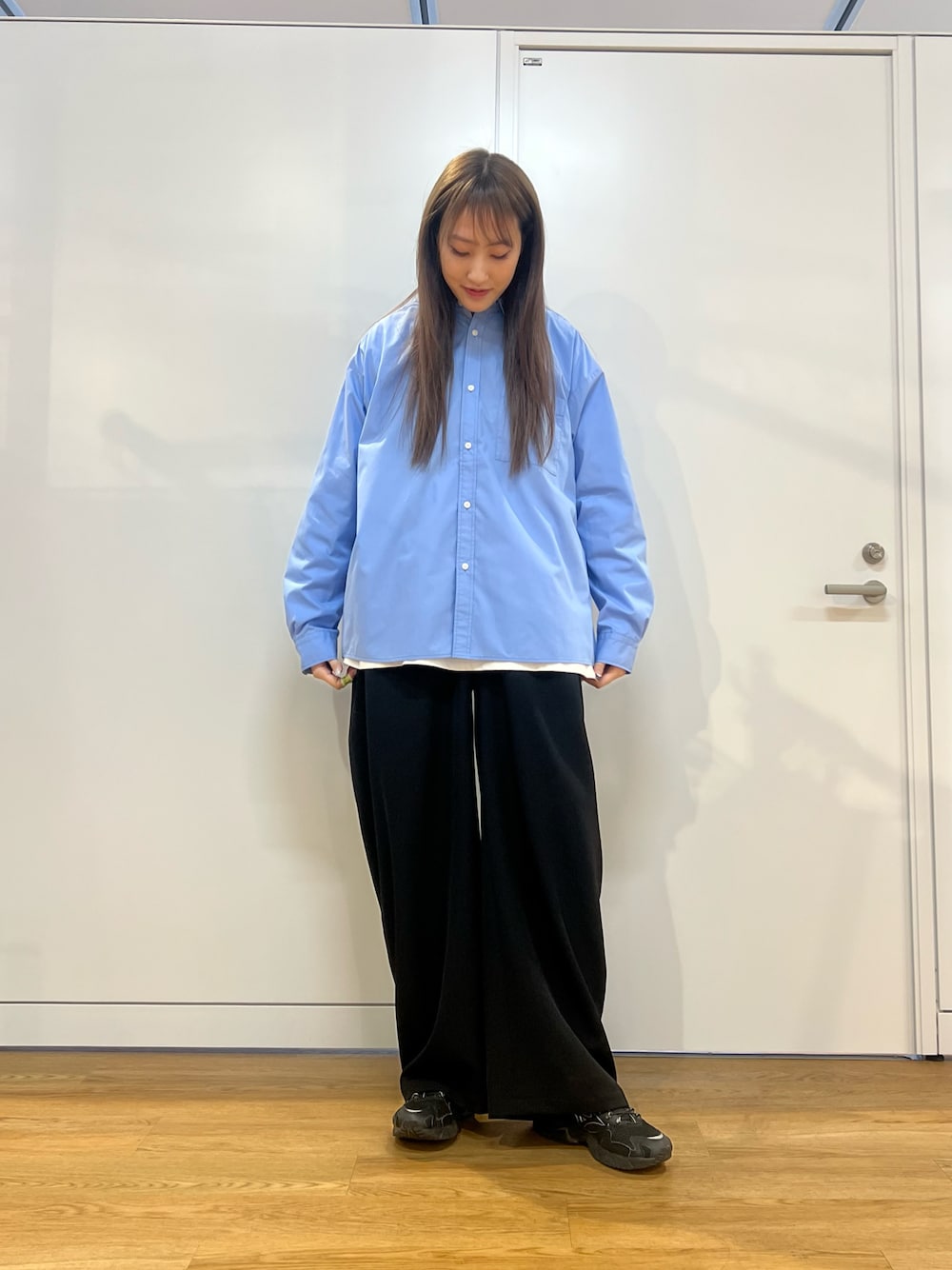 ブラック系のその他パンツ、ブルー系のビジネスシャツを着用したレディースの春コーディネートの1枚目の写真