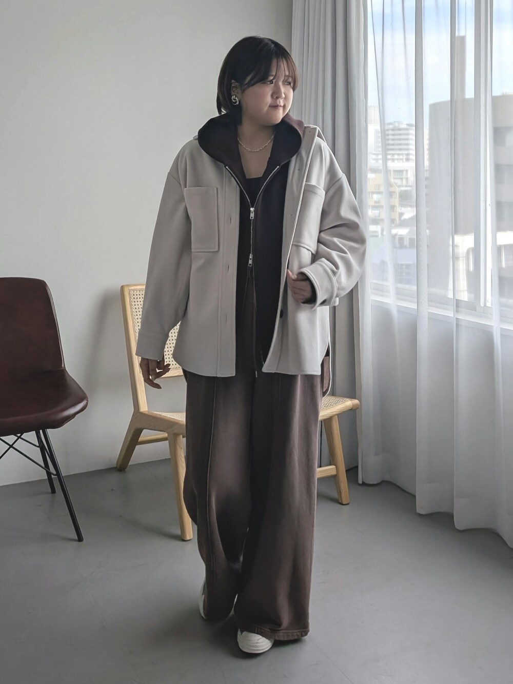 ブラウン系のパーカー、ブラウン系のスウェットパンツ、ベージュ系のその他アウターを着用したレディースの秋コーディネートの1枚目の写真