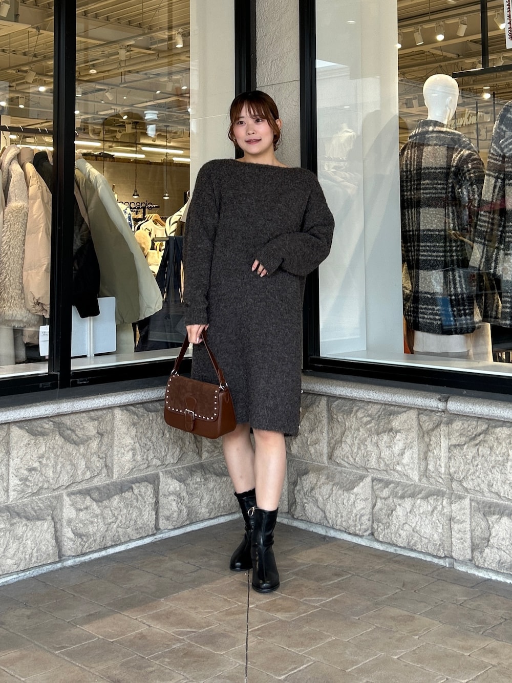 ブラウン系のチュニック、ブラック系のブーツを着用したレディースの冬コーディネートの1枚目の写真