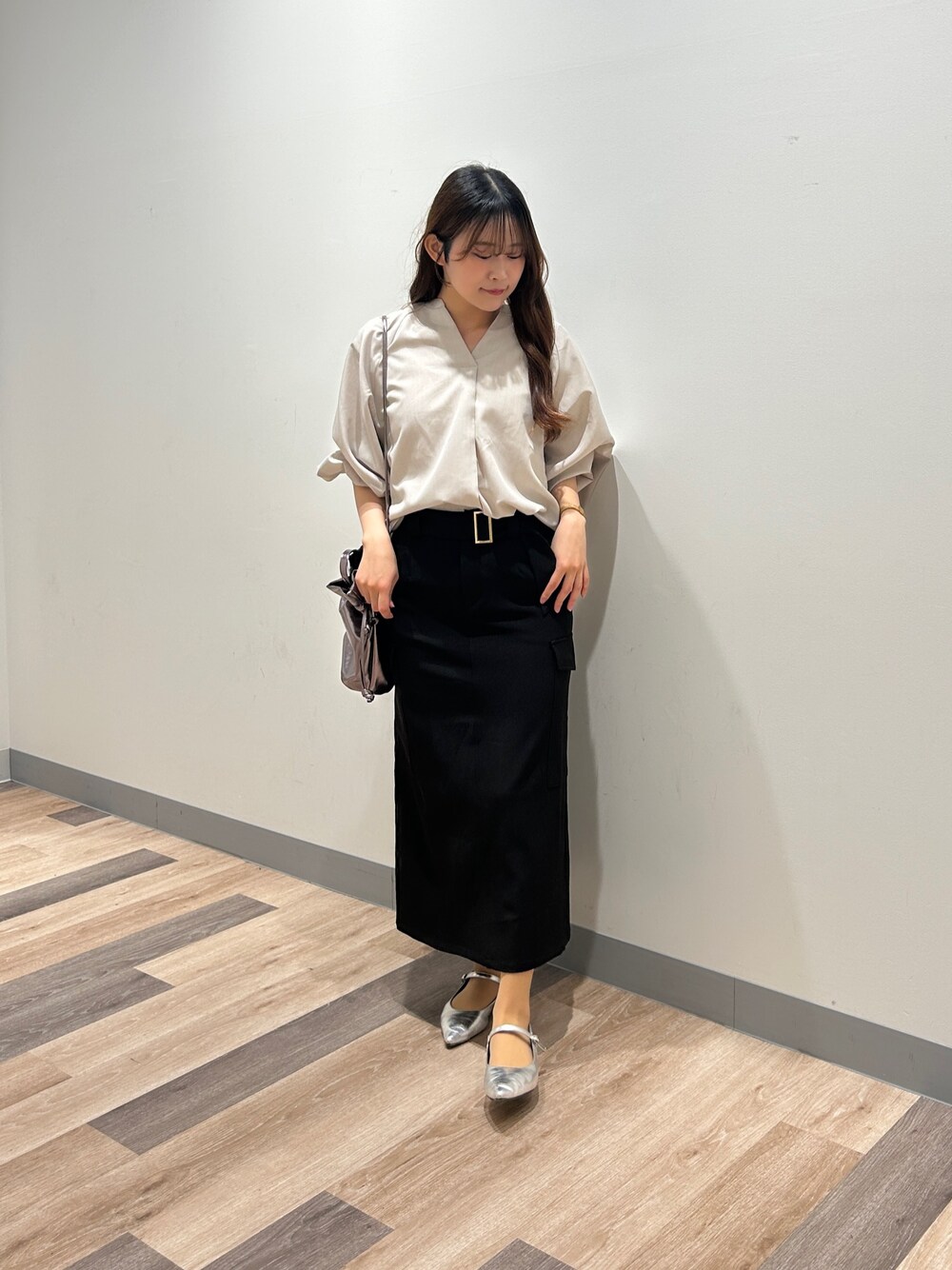 グレー系のシャツ/ブラウス、ブラック系のスカート、シルバー系のパンプスを着用したレディースの春コーディネートの1枚目の写真