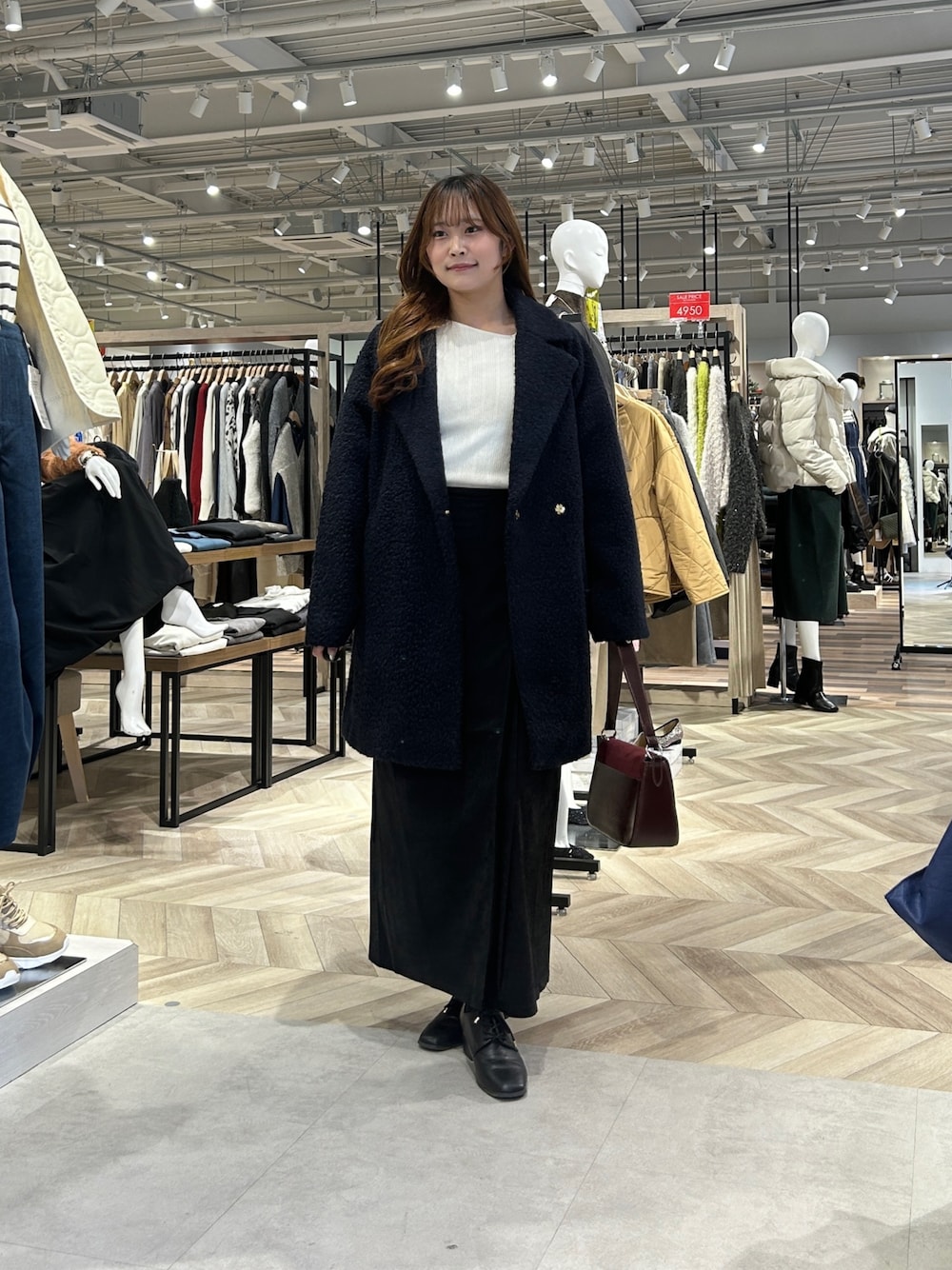 ブルー系のその他アウター、ホワイト系のニット/セーター、グレー系のスカートを着用したレディースの冬コーディネートの1枚目の写真