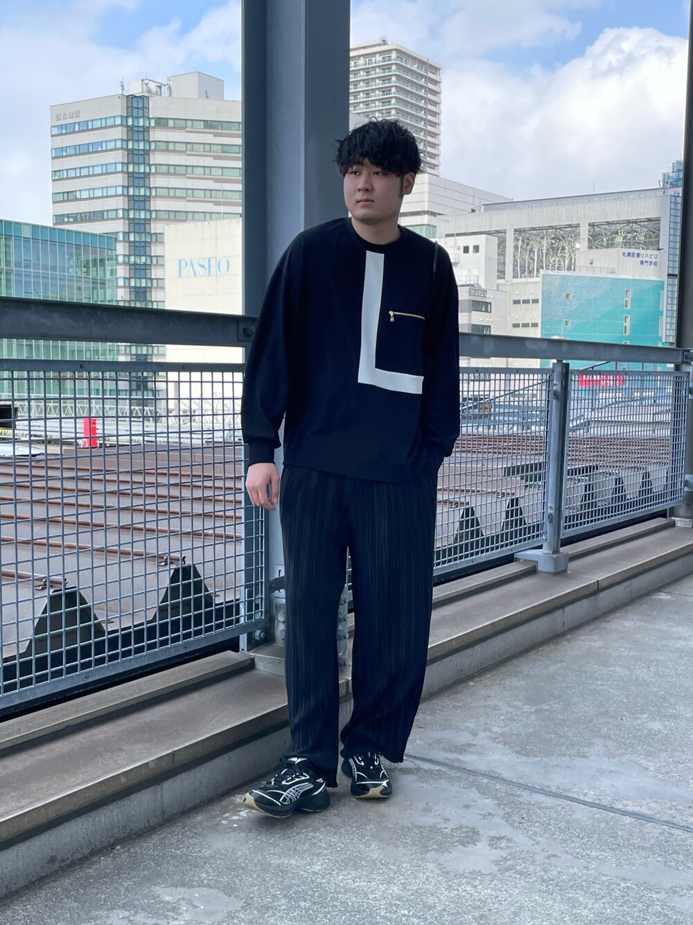 「クルニ、きれいめカジュアル、ルイス(Lui's)、プリーツパンツ、ワイドパンツ、トートバッグ、プーマ、スニーカー、オールブラック、モード、ビッグシルエット、モノトーン、春コーデ」｜「Lui'sのリラックス プリーツパンツ（その他パンツ、ブラック系）」を使った、Shu ⠀Iizukaさん（メンズ・187cm）の春コーディネートの1枚目の写真