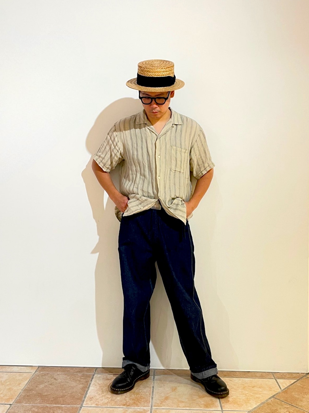 ベージュ系のシャツ/ブラウス、ブルー系のデニムパンツ、ブラック系のブーツを着用したメンズの夏コーディネートの1枚目の写真