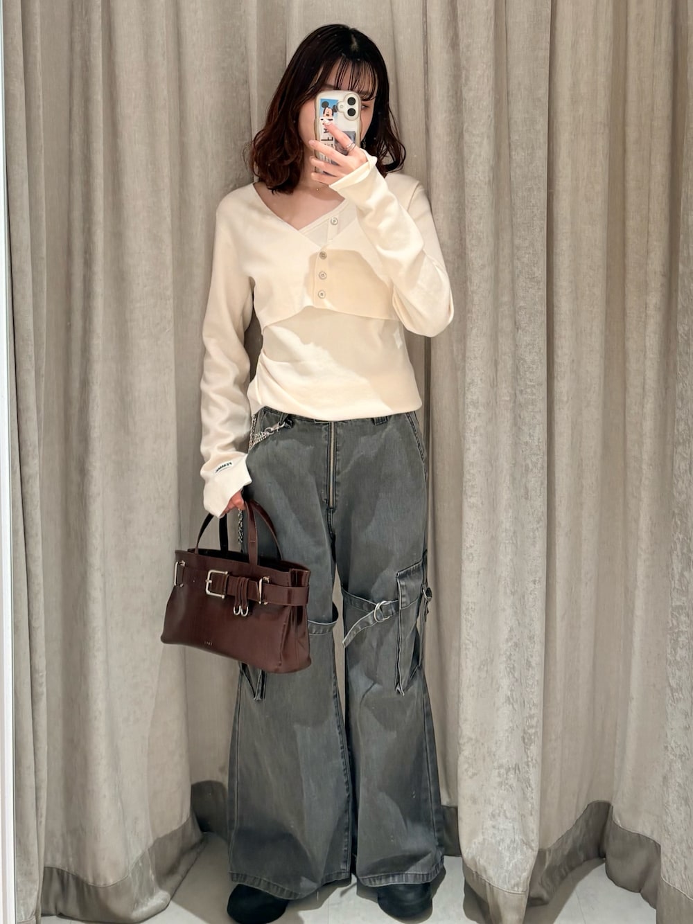 ホワイト系のニット/セーター、ブラック系のデニムパンツ、レッド系のボストンバッグを着用したレディースの冬コーディネートの1枚目の写真