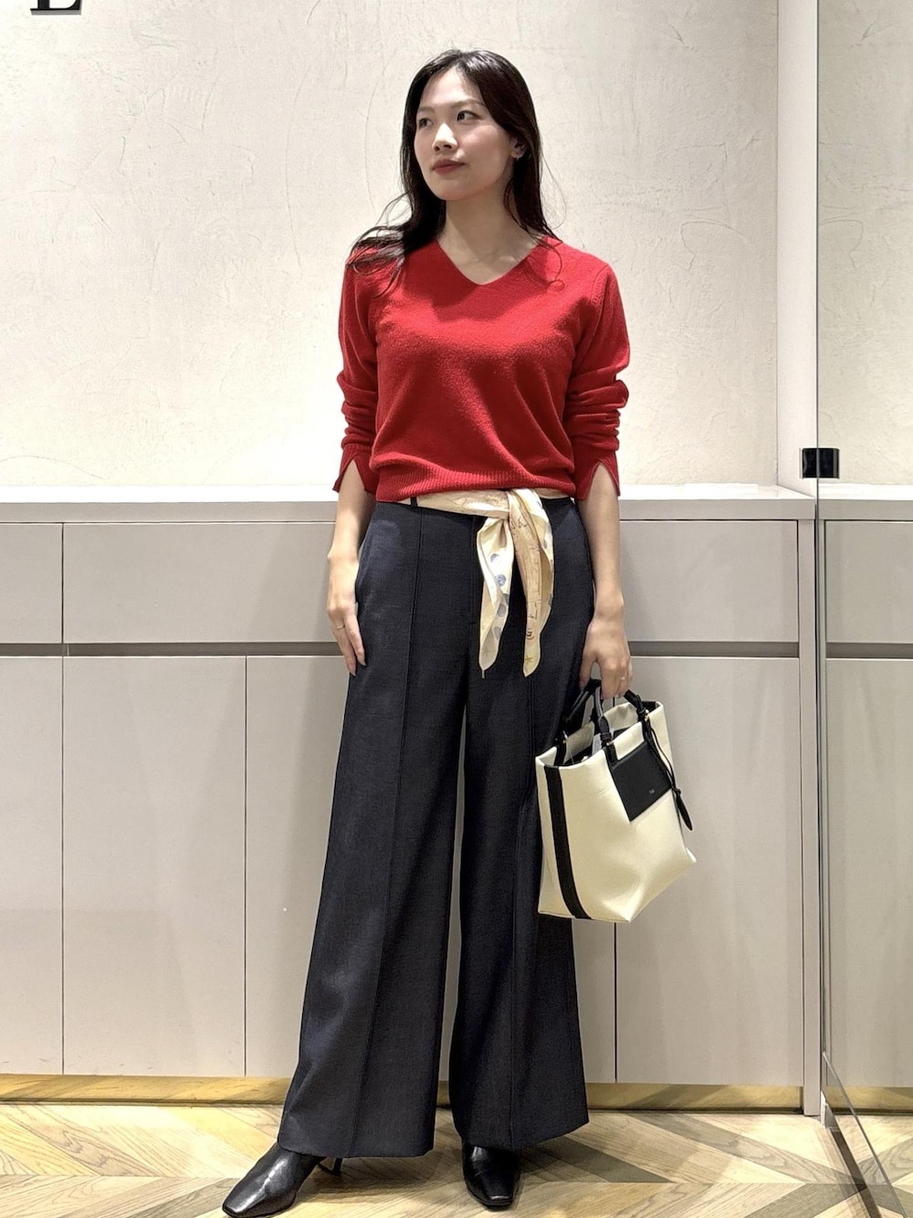 ホワイト系のトートバッグ、ブラック系のブーツ、ブルー系のその他パンツを着用したレディースの冬コーディネートの1枚目の写真