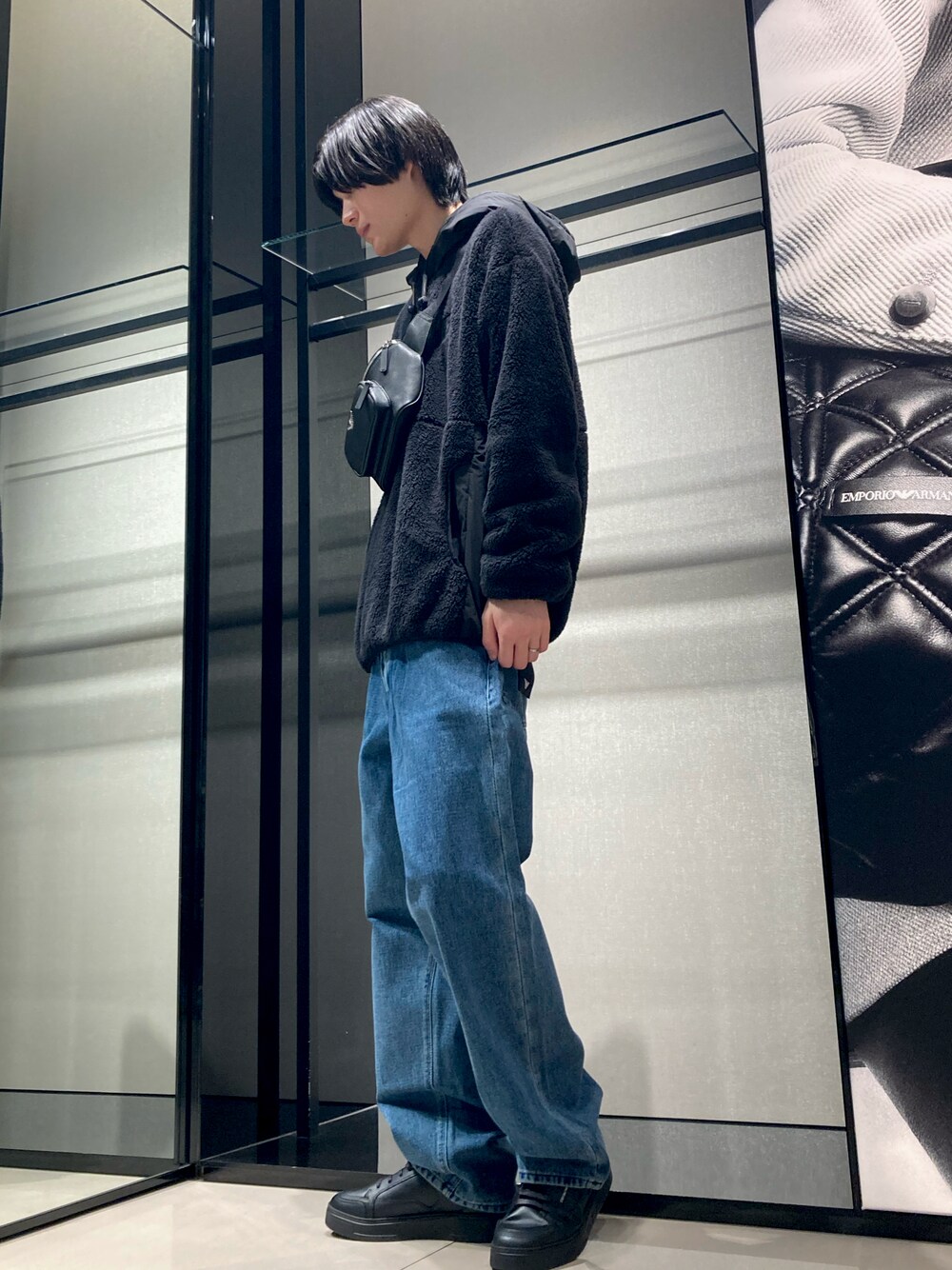 ブラック系のスウェット、ブルー系のデニムパンツ、ブラック系のボディバッグ/ウエストポーチを着用したメンズの冬コーディネートの1枚目の写真