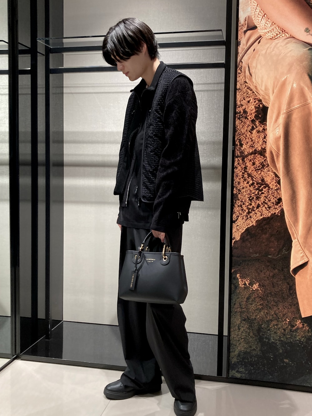 ブラック系のその他アウター、ブラック系のTシャツ/カットソー、ブラック系のスラックスを着用したメンズの春コーディネートの1枚目の写真