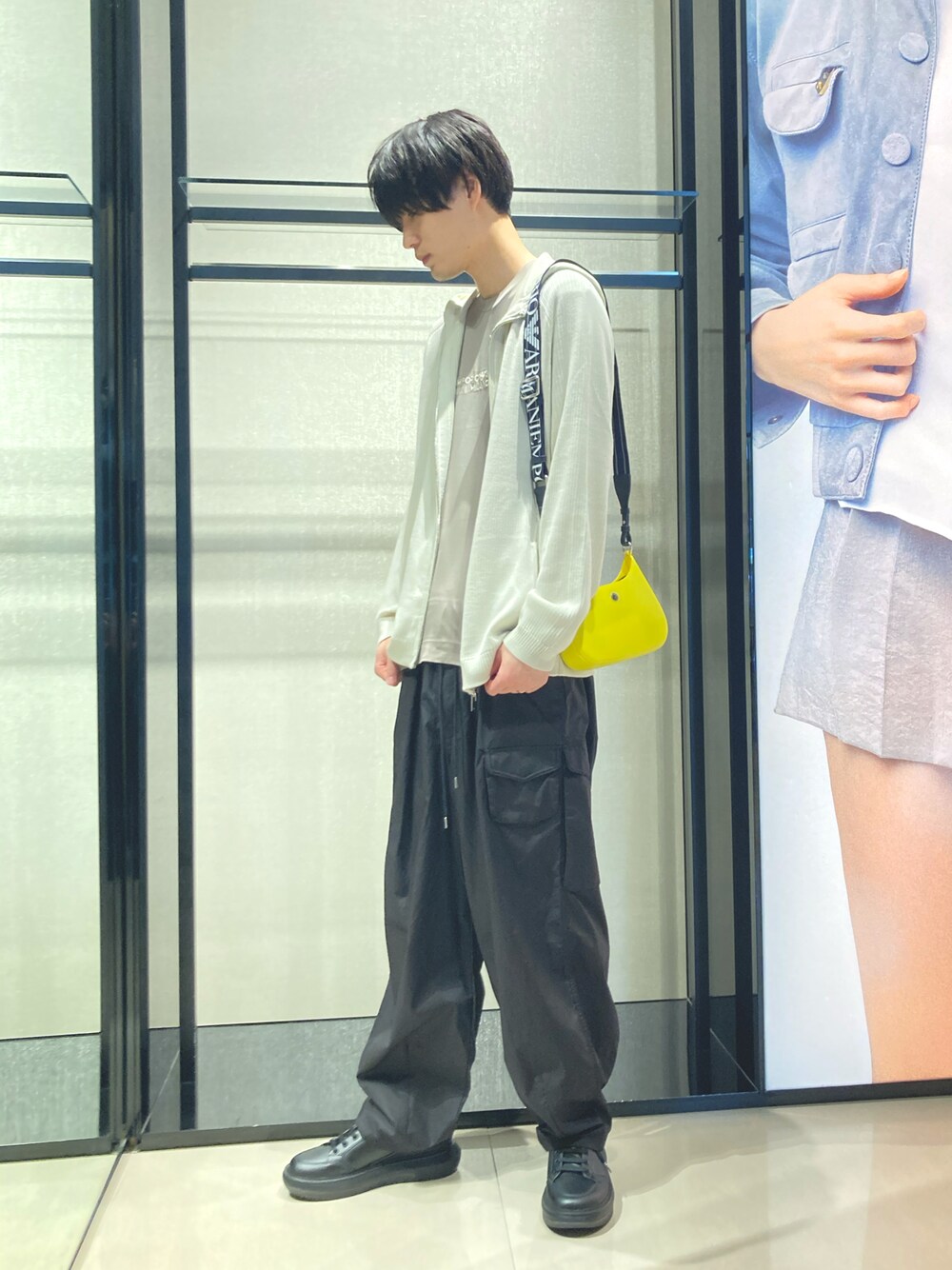 ブラック系のTシャツ/カットソー、ベージュ系のニット/セーター、イエロー系のショルダーバッグを着用したメンズの夏コーディネートの1枚目の写真