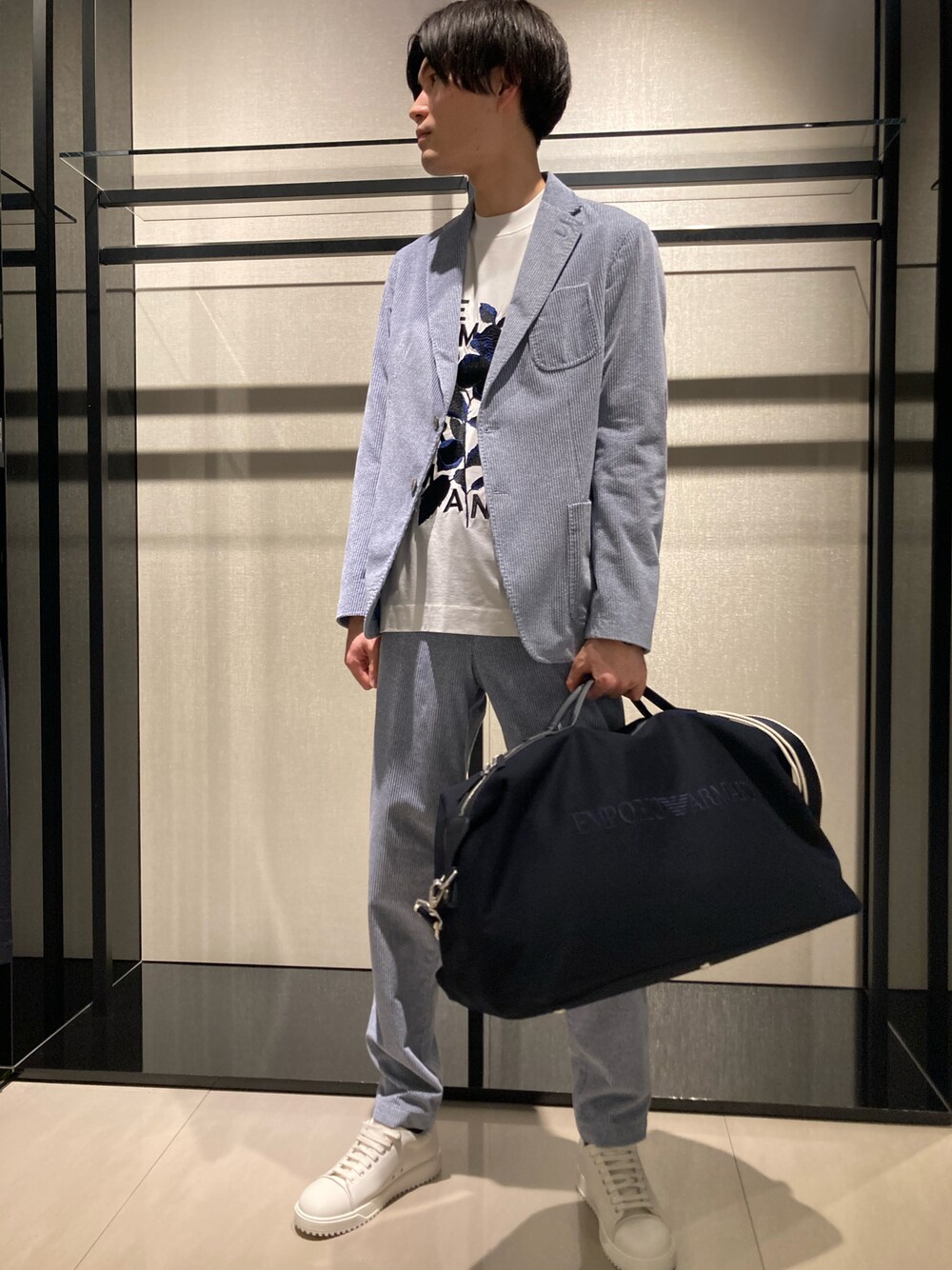 ブルー系のテーラードジャケット、ホワイト系のTシャツ/カットソー、ブラック系のボストンバッグを着用したメンズの冬コーディネートの1枚目の写真