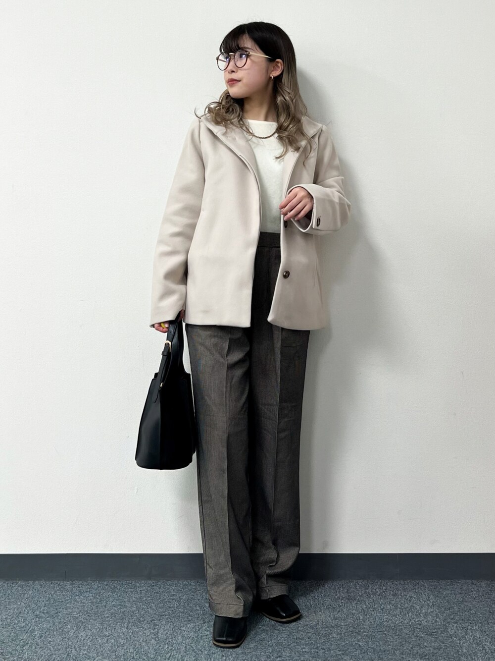 ベージュ系のその他アウター、ホワイト系のニット/セーター、ブラック系のトートバッグを着用したレディースの冬コーディネートの1枚目の写真