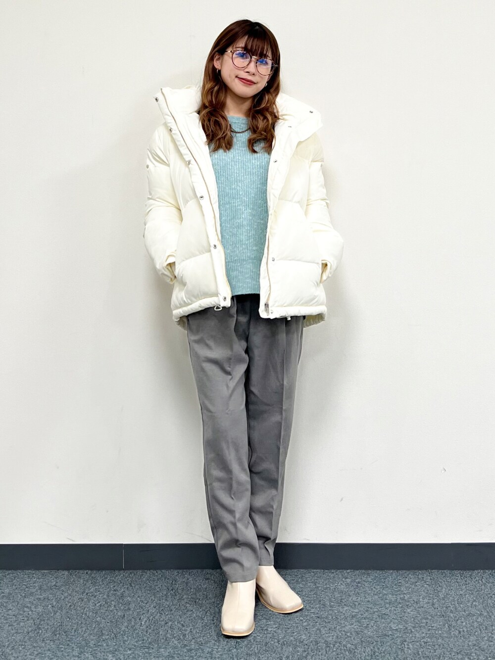 ホワイト系のブルゾン、ブルー系のニット/セーター、グレー系のその他パンツを着用したレディースの冬コーディネートの1枚目の写真