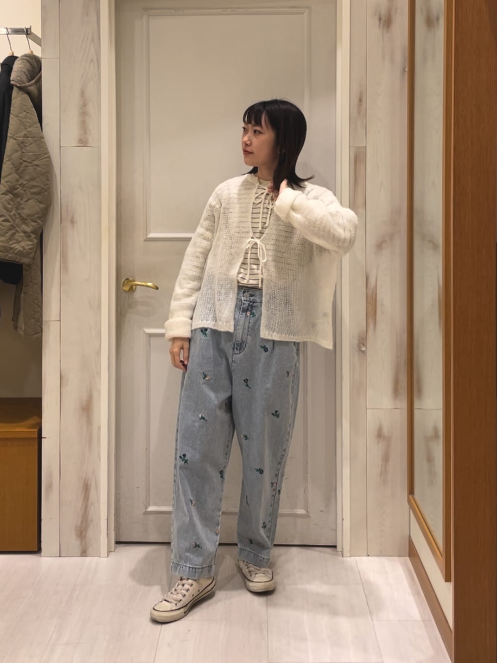 ブルー系のデニムパンツ、ホワイト系のカーディガン/ボレロを着用したレディースの冬コーディネートの1枚目の写真