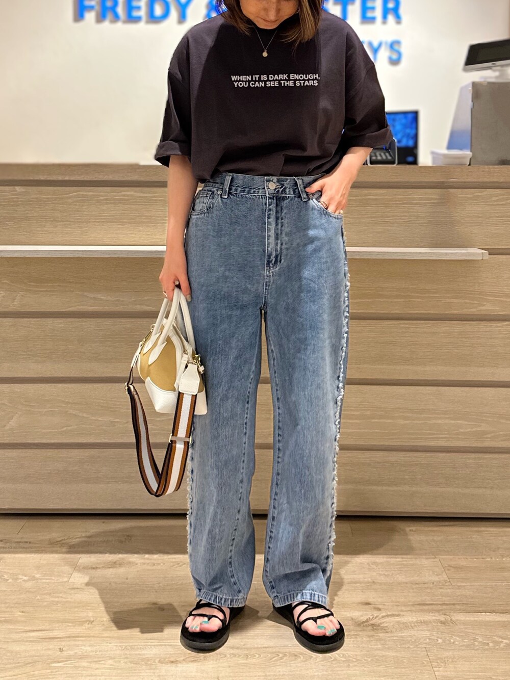 ホワイト系のショルダーバッグ、グレー系のTシャツ/カットソー、ブルー系のデニムパンツを着用したレディースの夏コーディネートの1枚目の写真