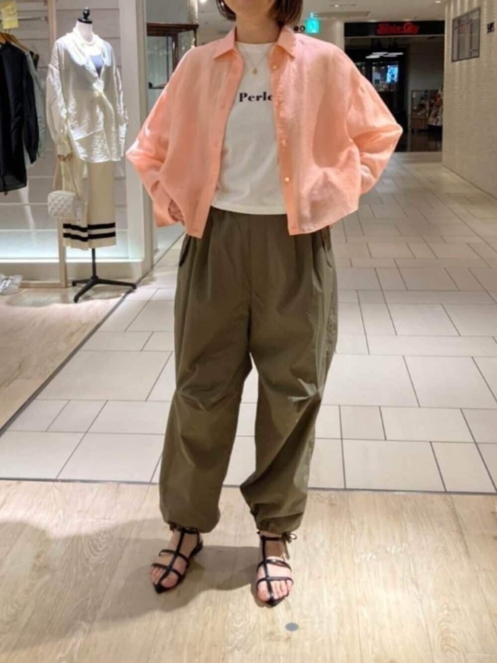 ピンク系のシャツ/ブラウス、ホワイト系のTシャツ/カットソー、グリーン系のその他パンツを着用したレディースの春コーディネートの1枚目の写真