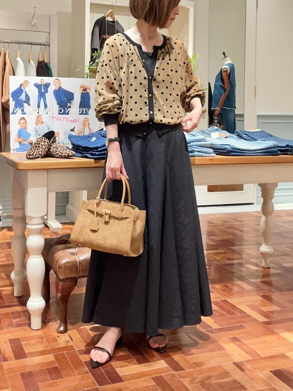 ブラック系のタンクトップ、イエロー系のカーディガン/ボレロ、ブラック系のスカートを着用したレディースの夏コーディネートの1枚目の写真