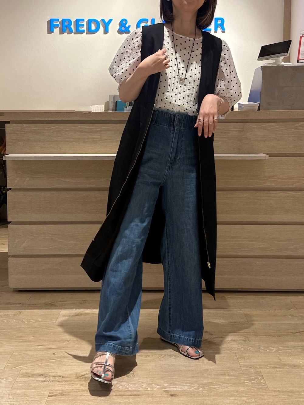 ホワイト系のシャツ/ブラウス、シルバー系のサンダル、ブルー系のデニムパンツを着用したレディースの夏コーディネートの1枚目の写真