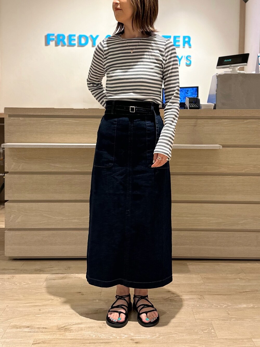 グレー系のTシャツ/カットソー、ブルー系のデニムスカートを着用したレディースの夏コーディネートの1枚目の写真