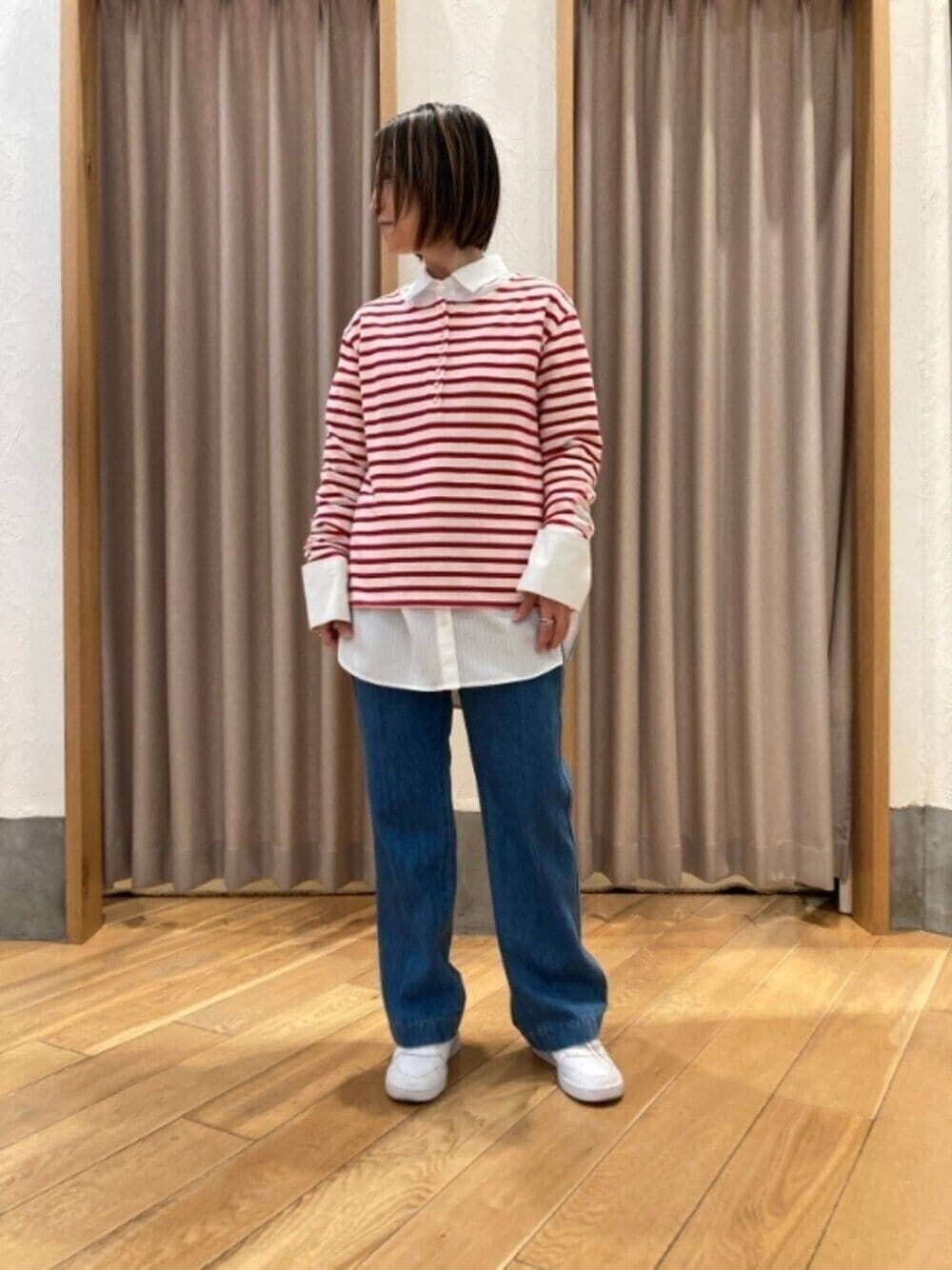 レッド系のTシャツ/カットソー、ホワイト系のシャツ/ブラウス、ブルー系のデニムパンツを着用したレディースの冬コーディネートの1枚目の写真