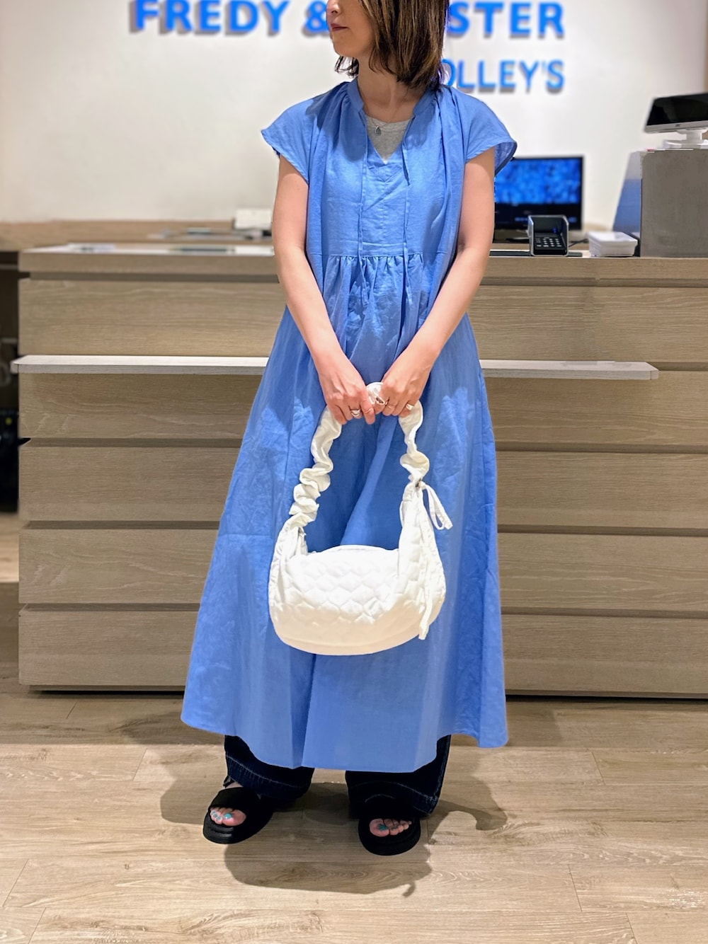 ホワイト系のショルダーバッグ、ブルー系のワンピース、ブルー系のデニムパンツを着用したレディースの夏コーディネートの1枚目の写真