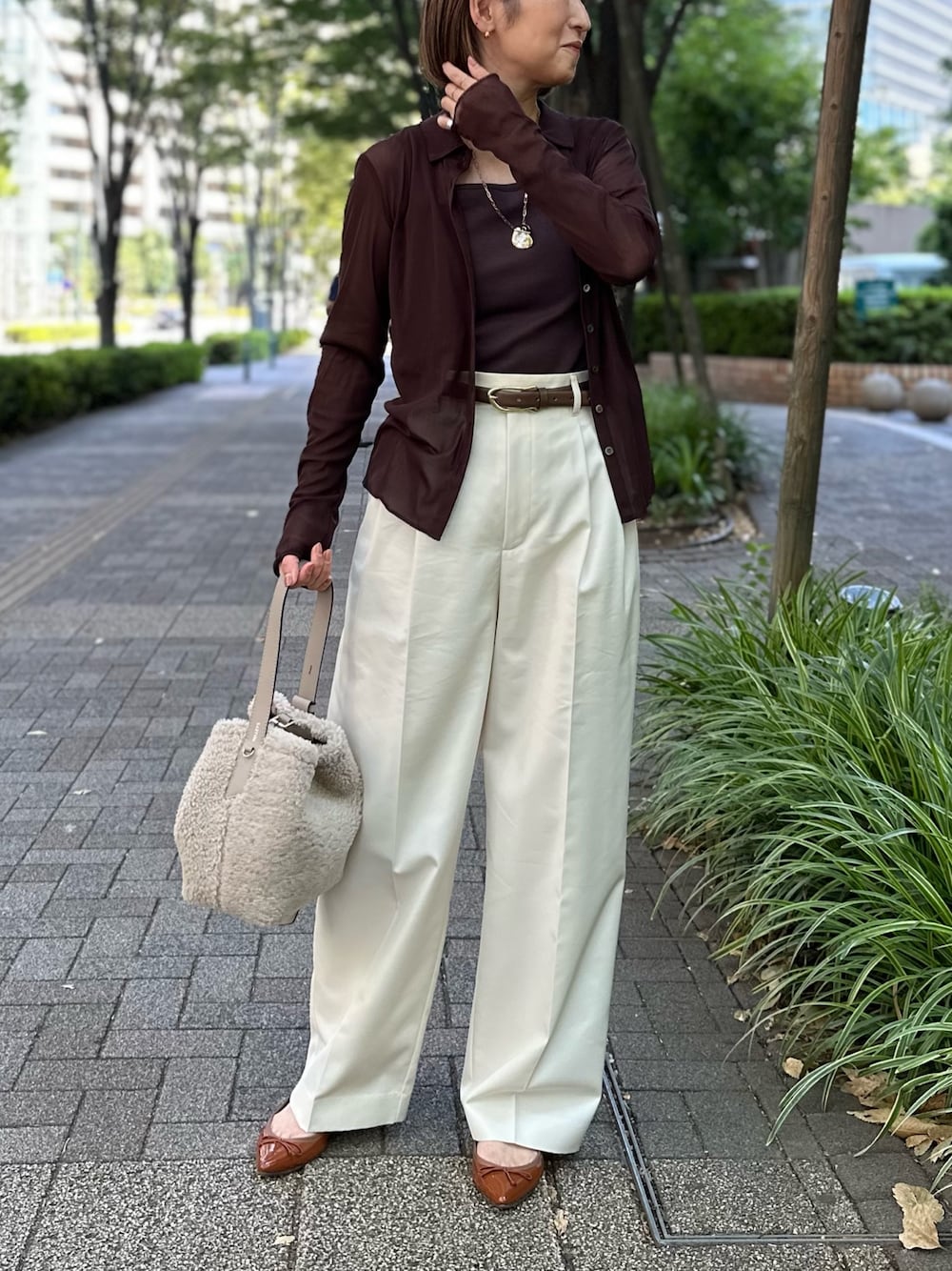 ブラウン系のカーディガン/ボレロ、ブラウン系のタンクトップ、ホワイト系のその他パンツを着用したレディースの秋コーディネートの1枚目の写真