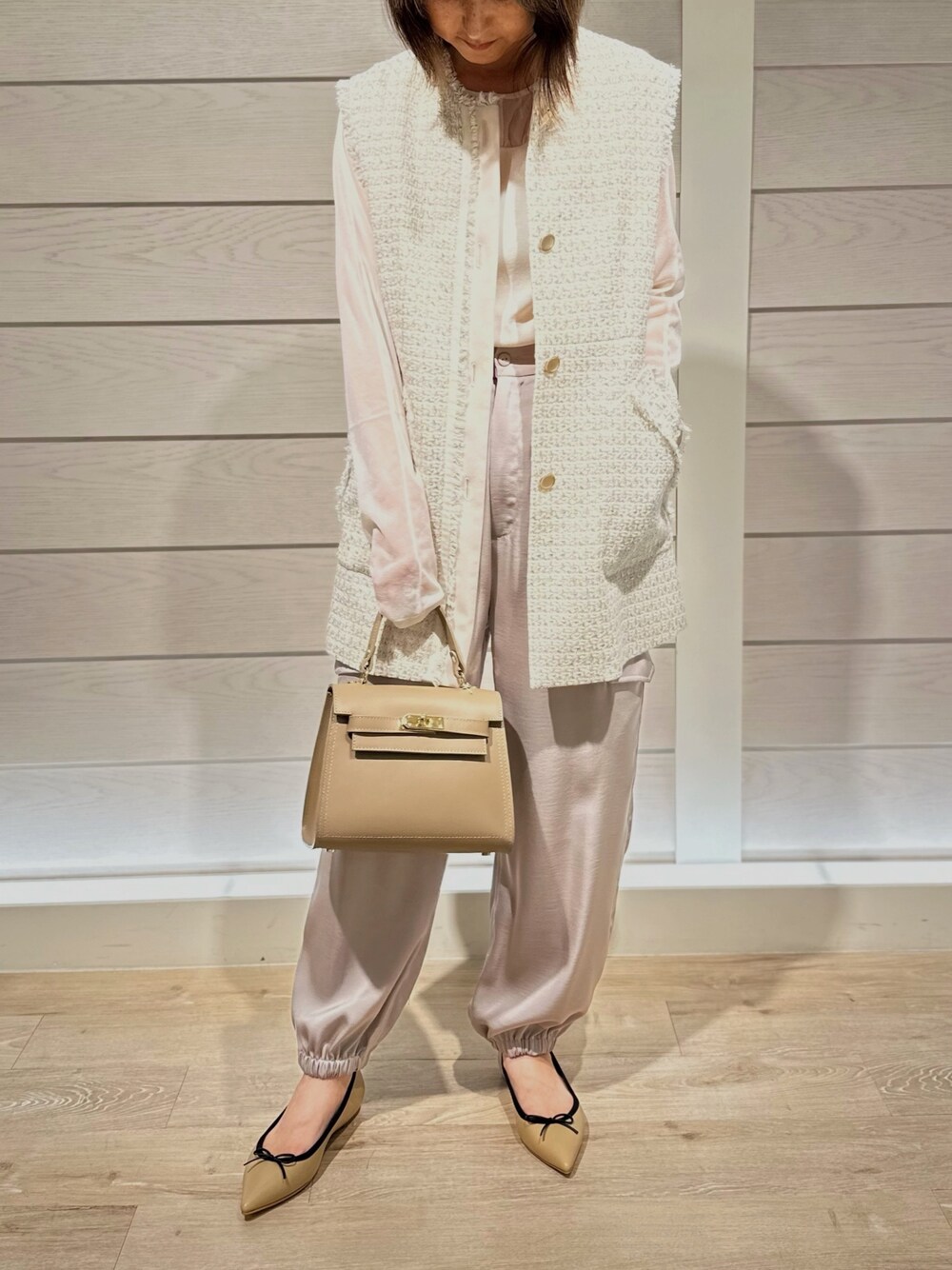 ベージュ系のショルダーバッグ、ベージュ系のパンプス、ベージュ系のカーゴパンツを着用したレディースの秋コーディネートの1枚目の写真