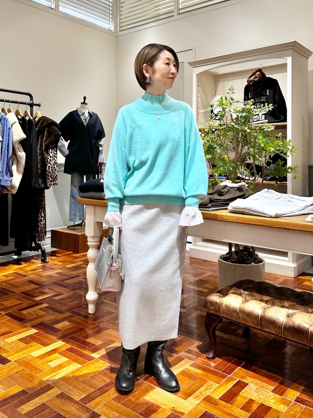 グレー系のスカート、シルバー系のショルダーバッグ、ホワイト系のシャツ/ブラウスを着用したレディースの秋コーディネートの1枚目の写真