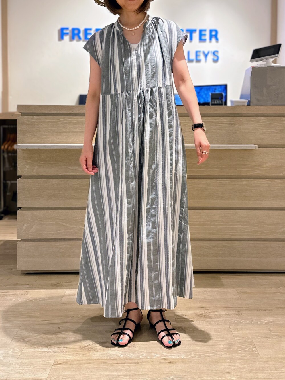 ブラック系のワンピース、ベージュ系のハットを着用したレディースの夏コーディネートの1枚目の写真