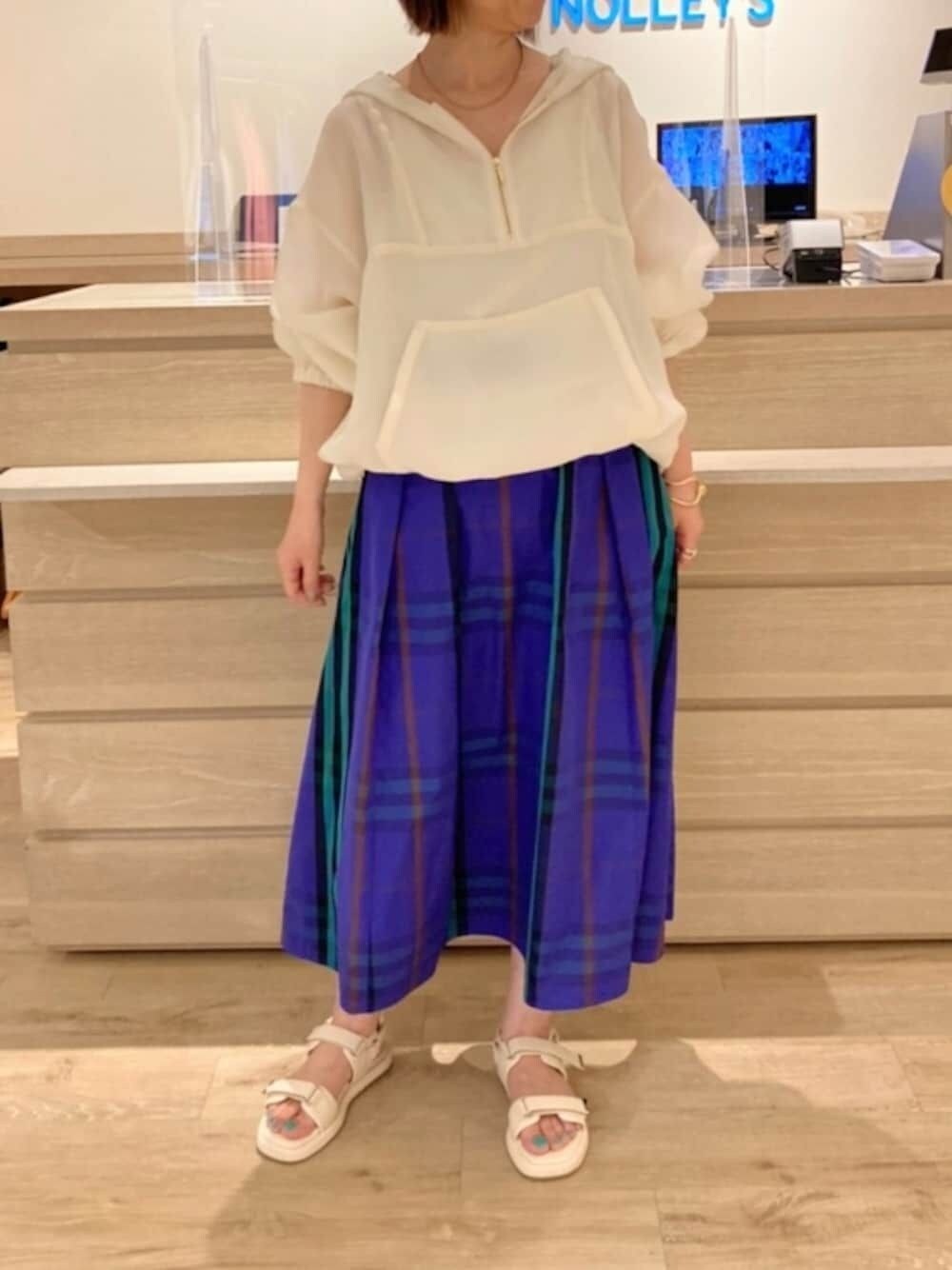 ホワイト系のブルゾン、ホワイト系のタンクトップ、ブルー系のスカートを着用したレディースの春コーディネートの1枚目の写真