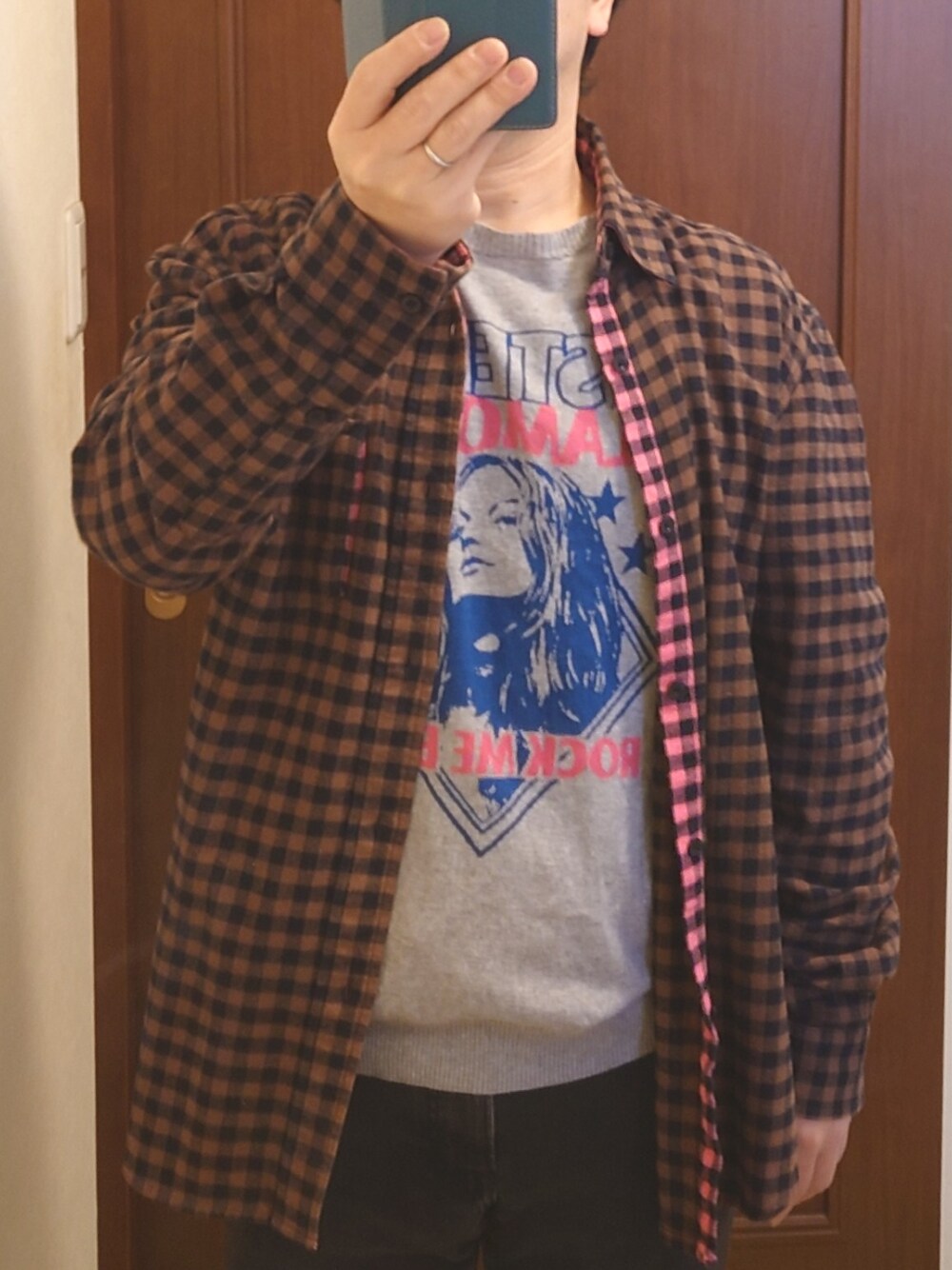 グレー系のニット/セーター、ブラウン系のシャツ/ブラウス、ブラック系のデニムパンツを着用したメンズの春コーディネートの1枚目の写真