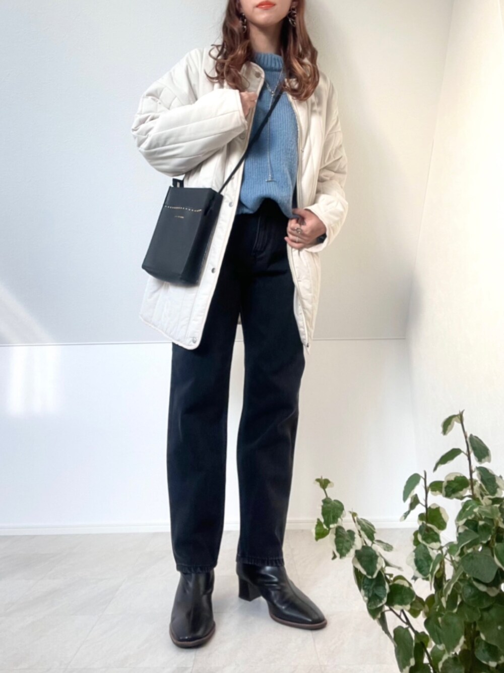 ホワイト系のノーカラーコート、ブラック系のデニムパンツ、ブルー系のニット/セーターを着用したレディースの秋コーディネートの1枚目の写真