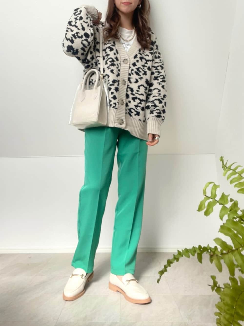 グリーン系のスラックス、その他のカーディガン/ボレロ、ホワイト系のローファーを着用したレディースの冬コーディネートの1枚目の写真