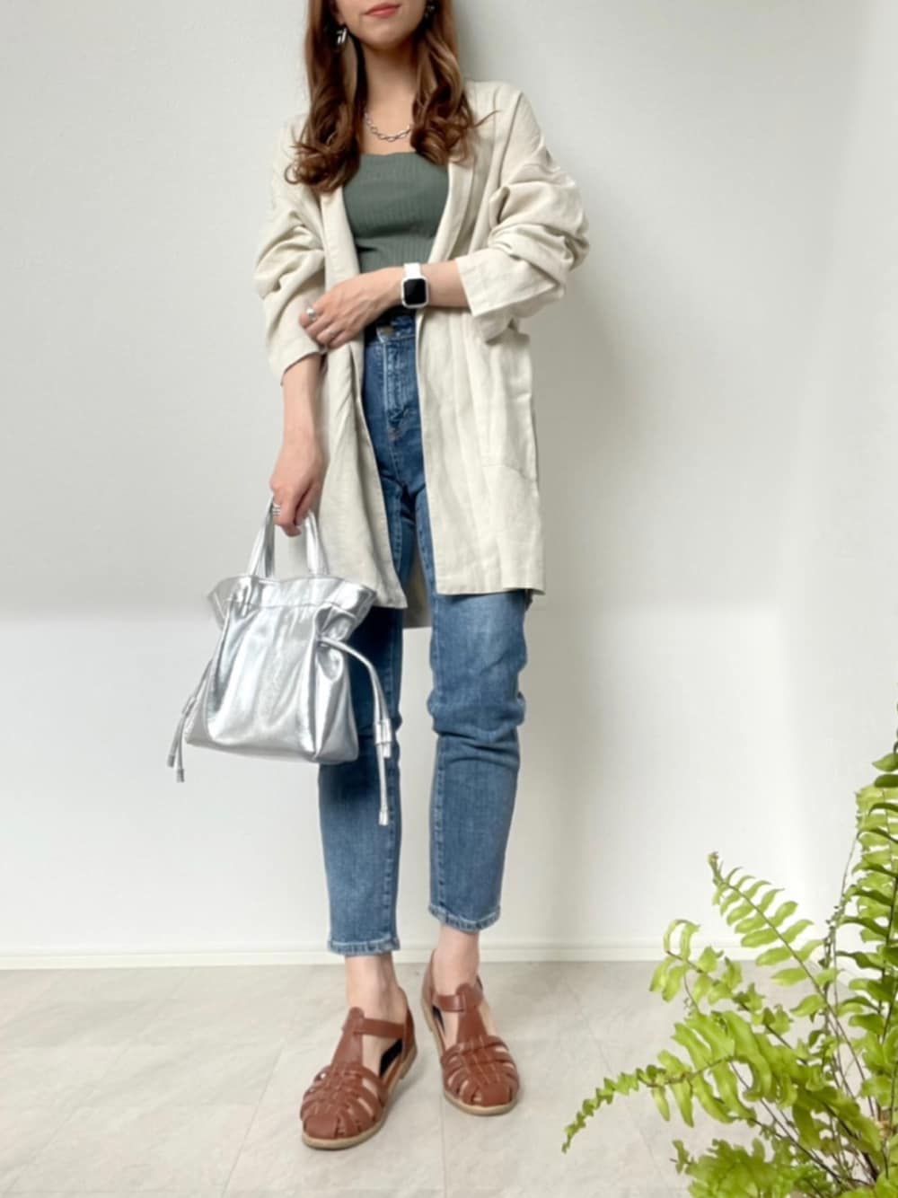 ホワイト系のその他アウター、ブルー系のデニムパンツ、シルバー系のショルダーバッグを着用したレディースの春コーディネートの1枚目の写真